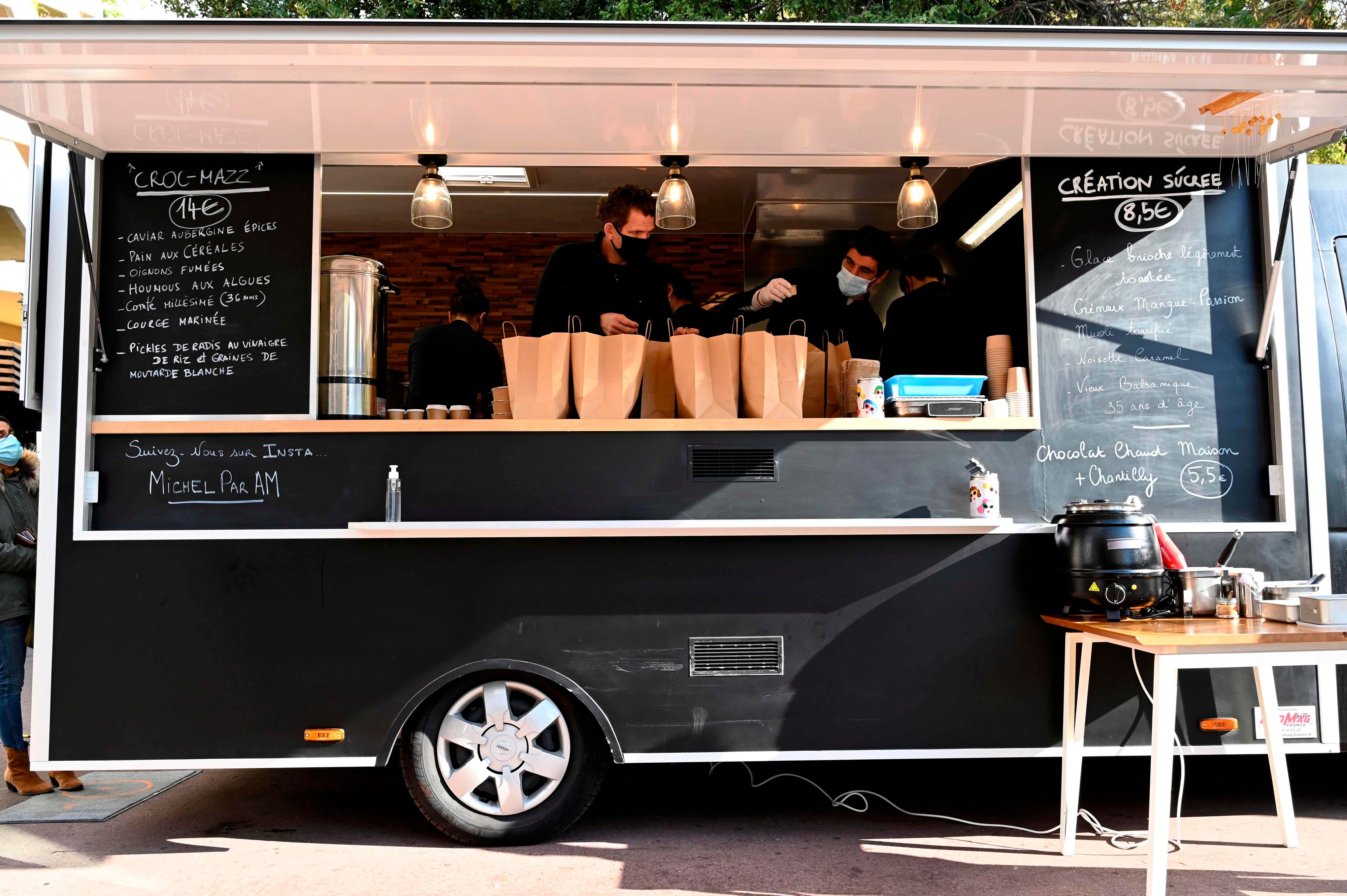 Download von www.picturedesk.com am 23.01.2021 (22:32).  French chef Alexandre Mazzia (L) and his team prepare takeaway meals in a food-truck in Marseille, southern France, on November 24, 2020. - Mazzia, who was appointed "French chef of the year" in 2018 and whose restaurant "AM" in Marseille was awarded with two stars at the Michelin guide, has developed a new way to sell his food as he faces the closure of his restaurant due to the second lockdown aimed at halting an alarming acceleration of Covid-19 cases. (Photo by NICOLAS TUCAT / AFP) - 20201124_PD3242 - Rechteinfo: Rights Managed (RM) Nur für redaktionelle Nutzung! Werbliche Nutzung erfordert Freigabe: bitte schicken Sie uns eine Anfrage.