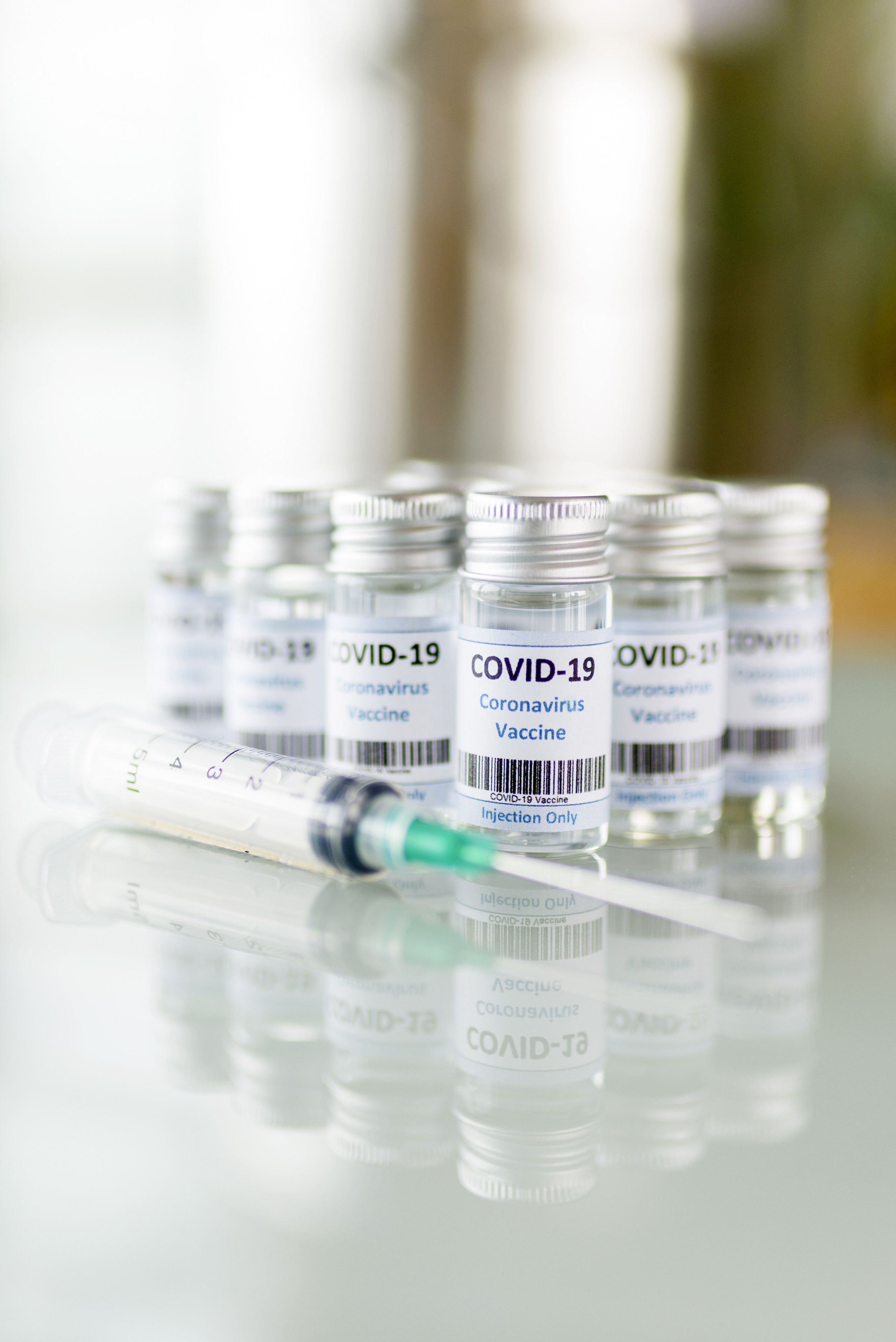 Impfdosen und Impfspritzen stehen auf einem Tisch. Symbolbild