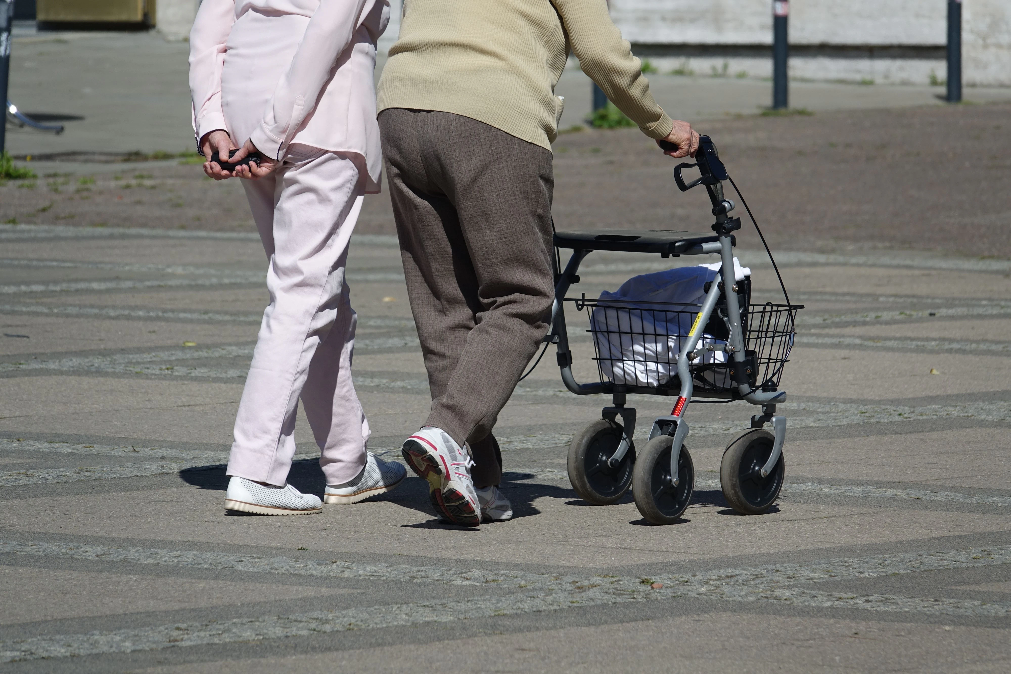 Zwei Senioren unterwegs mit einem Rollator. Symbolbild