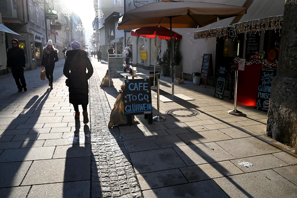 Passanten gehen im Gegenlicht in einer Einkaufsstraße. (Symbolbild)