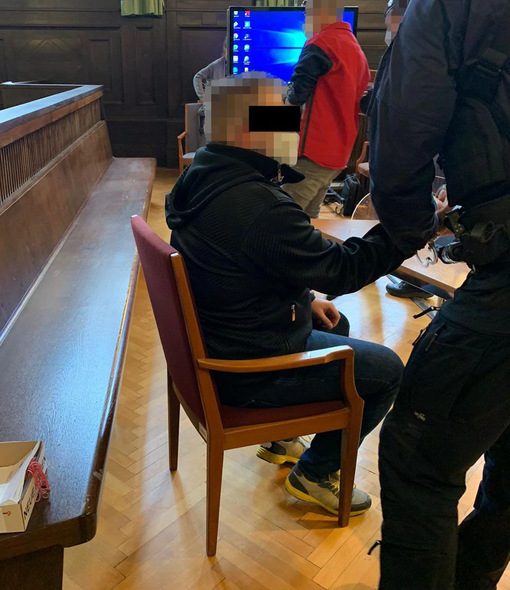 Eisstockfunktionär (sitzend) und mit roter Jacke: Mitangeklagter