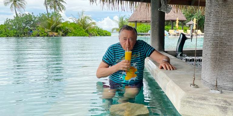 Richard Lugner sucht beim Baden Schutz vorm Regen.