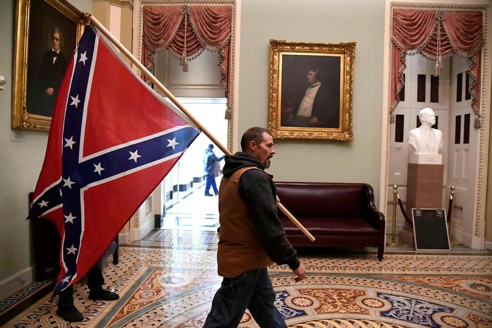 Ein Trump-Anhänger im Inneren des Capitols mit einer Konföderierten-Fahne.