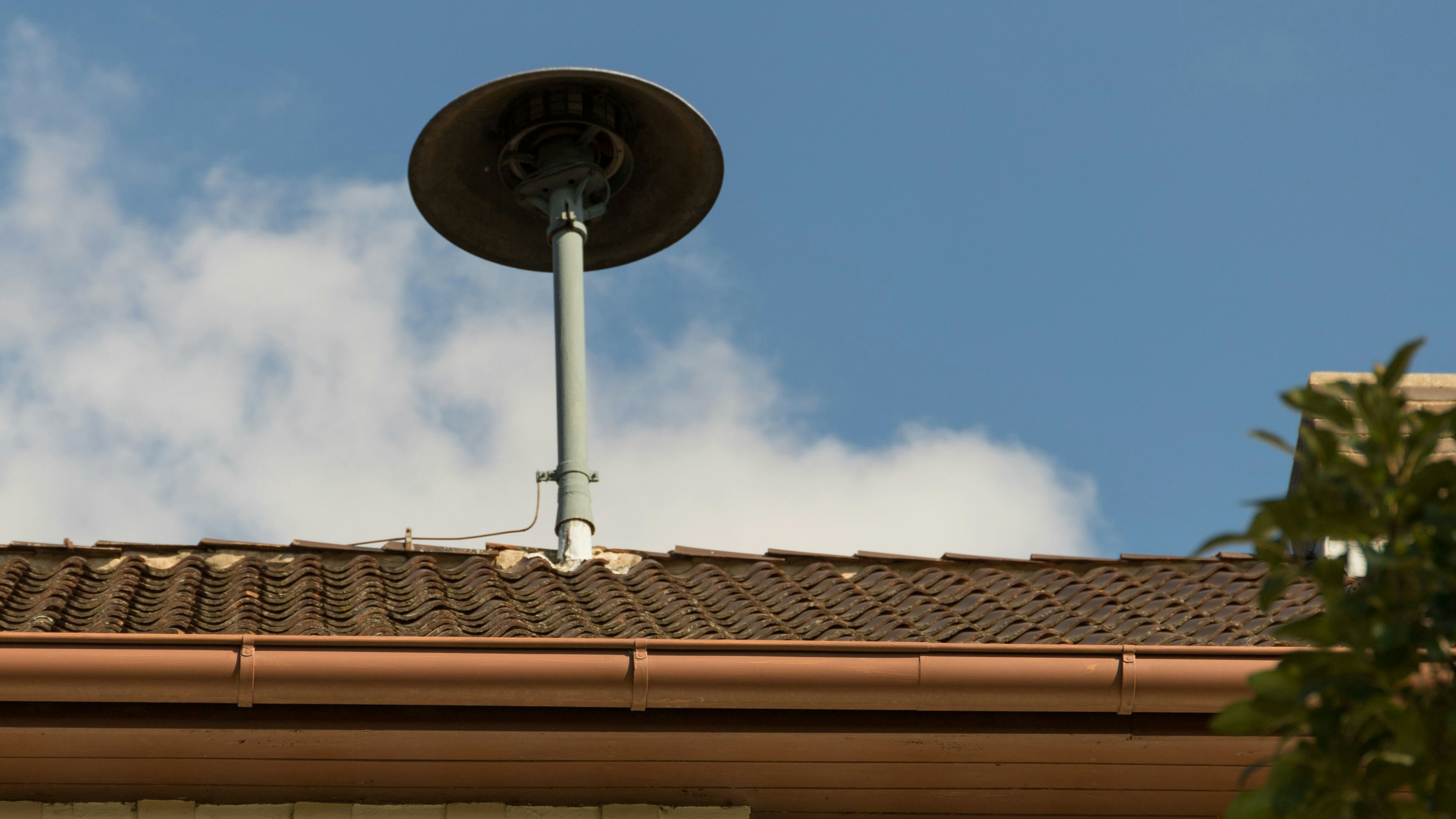 Fire siren on a roof in a village with blue sky