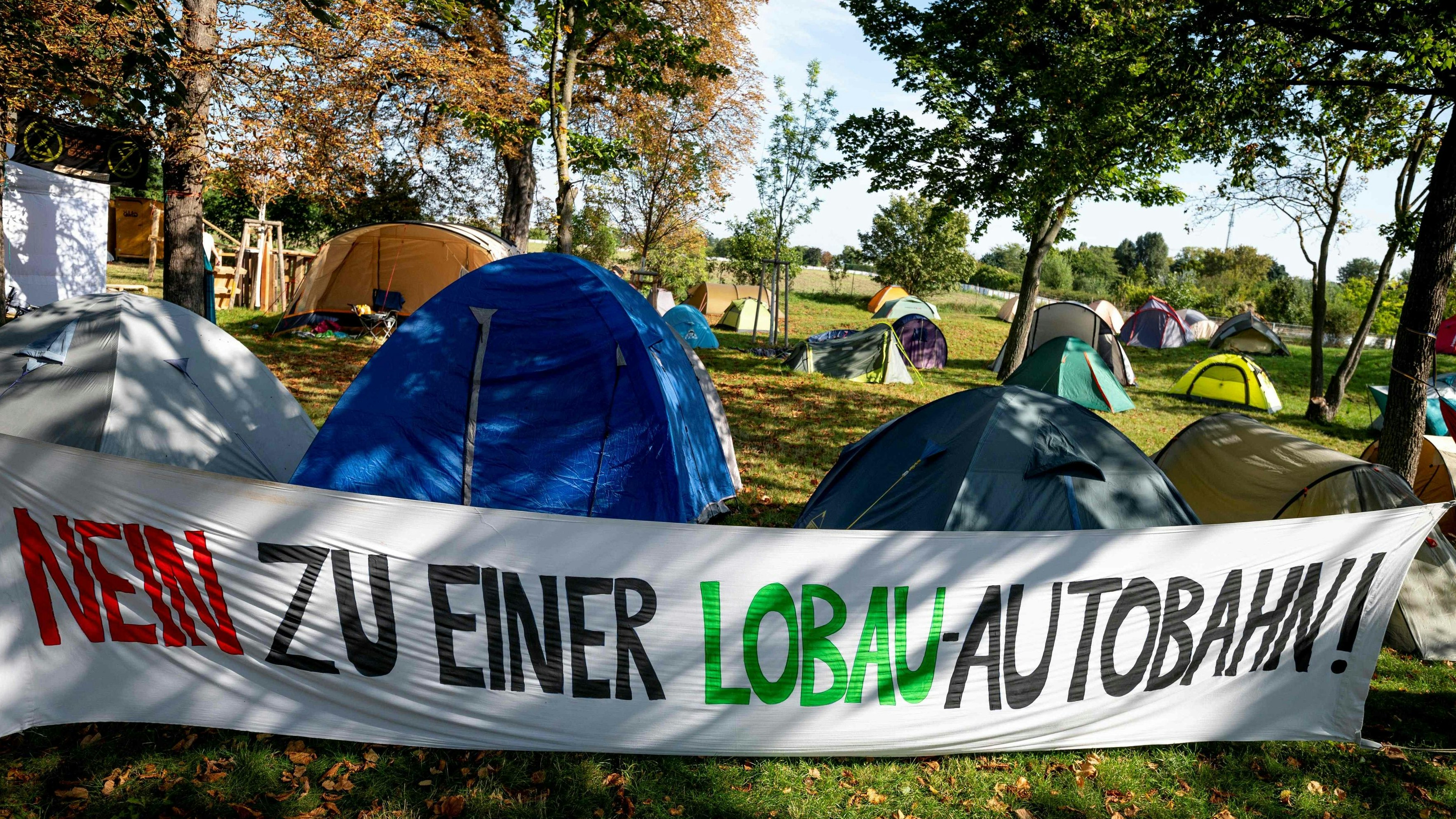Download von www.picturedesk.com am 05.10.2021 (10:37).  A banner with the lettering reading 'No To Lobau Highway' is seen at a camp set up by an alliance of activists of Fridays for Future, Jugendrat, Extinction Rebellion, System Change and others in a national park that they say is threatened by the construction of a highway in Vienna, Austria on September 23, 2021. - Activists seek to prevent the construction of a planned highway tunnel under part of the Lobau national park meant to ease traffic flow east of the capital Vienna. (Photo by JOE KLAMAR / AFP) - 20210923_PD4477 - Rechteinfo: Rights Managed (RM) Nur für redaktionelle Nutzung! Werbliche Nutzung erfordert Freigabe: bitte schicken Sie uns eine Anfrage.