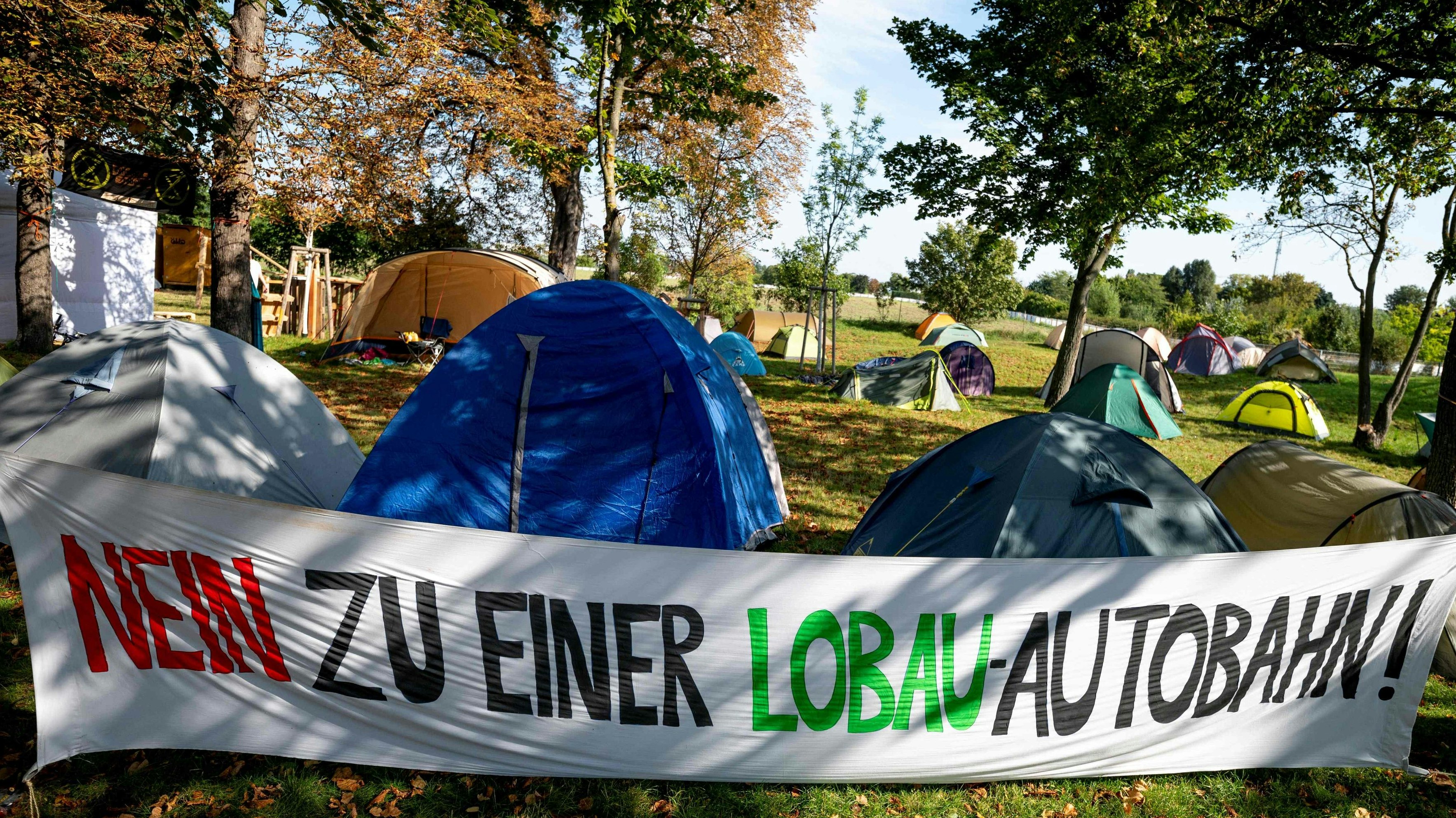 Download von www.picturedesk.com am 05.10.2021 (10:37).  A banner with the lettering reading 'No To Lobau Highway' is seen at a camp set up by an alliance of activists of Fridays for Future, Jugendrat, Extinction Rebellion, System Change and others in a national park that they say is threatened by the construction of a highway in Vienna, Austria on September 23, 2021. - Activists seek to prevent the construction of a planned highway tunnel under part of the Lobau national park meant to ease traffic flow east of the capital Vienna. (Photo by JOE KLAMAR / AFP) - 20210923_PD4477 - Rechteinfo: Rights Managed (RM) Nur für redaktionelle Nutzung! Werbliche Nutzung erfordert Freigabe: bitte schicken Sie uns eine Anfrage.