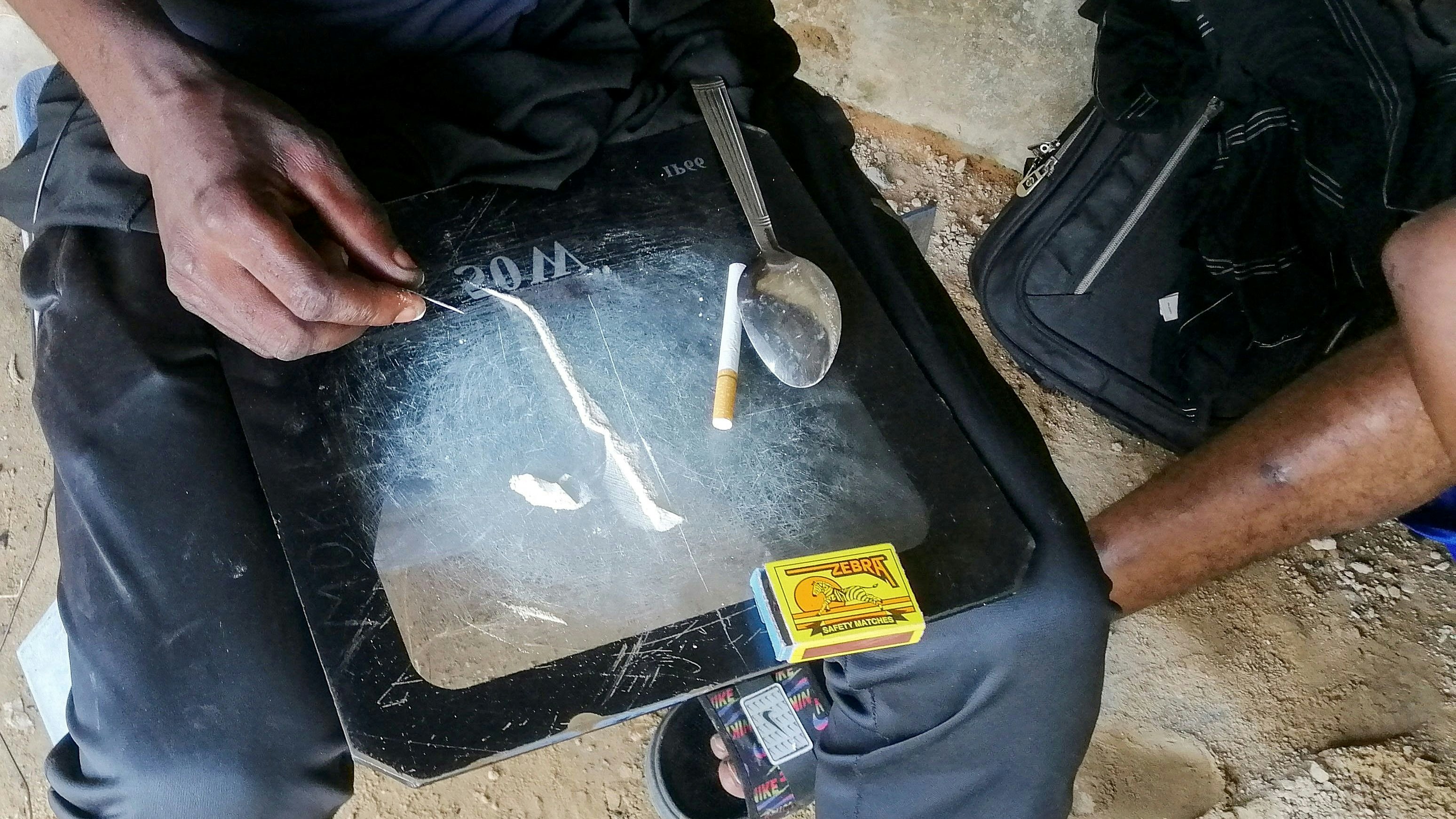 A man shows a substance known as "bombe", a mix of catalytic converters' crushed honeycomb and pills, before snorting it, in Kinshasa, Democratic Republic of the Congo August 31, 2021. Picture taken August 31, 2021. REUTERS/Benoit Nyemba