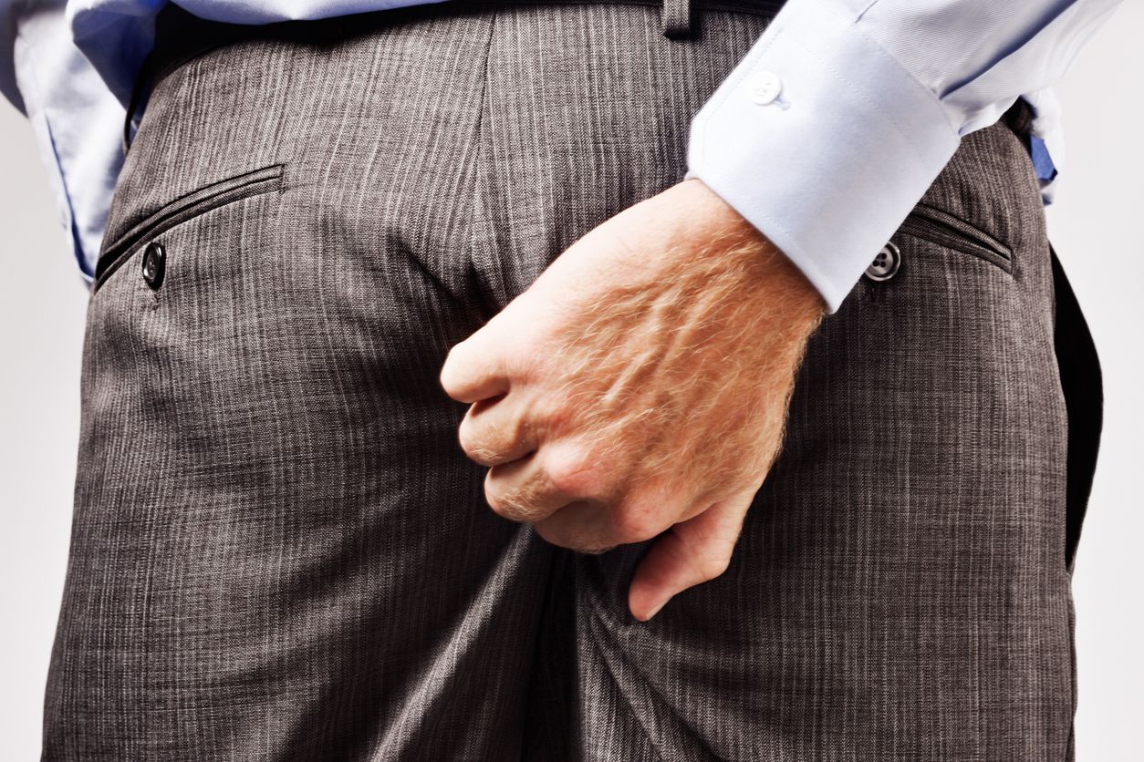 Rude businessman scratches his buttocks - NOT something to do in public!