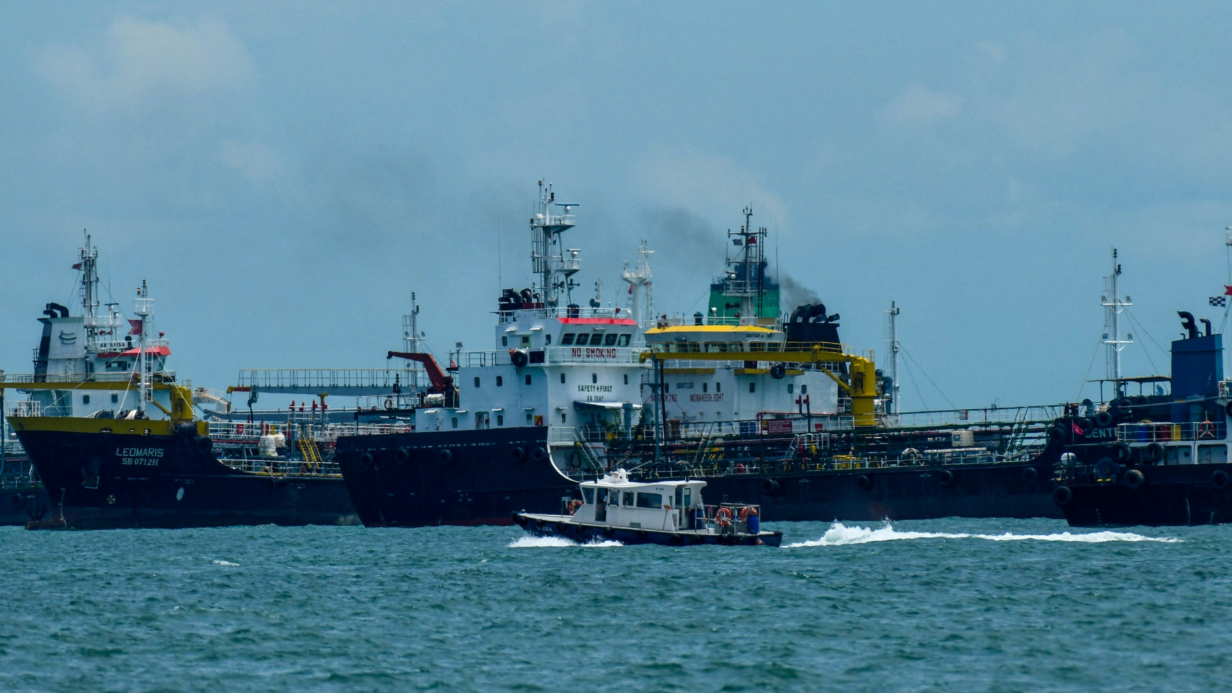 Download von www.picturedesk.com am 11.10.2021 (11:04).  A boat sails past oil tankers anchored along the East Coast waterway in Singapore on October 11, 2021. (Photo by Roslan RAHMAN / AFP) - 20211011_PD0510 - Rechteinfo: Rights Managed (RM) Nur für redaktionelle Nutzung! Werbliche Nutzung erfordert Freigabe: bitte schicken Sie uns eine Anfrage.