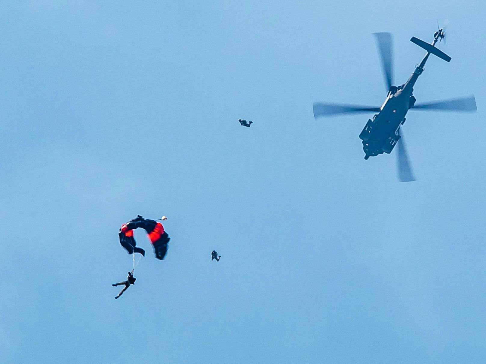 Soldaten des Österreichischen Bundesheeres bei einem Fallschrimsprung aus einem Black Hawk-Hubschrauber.
