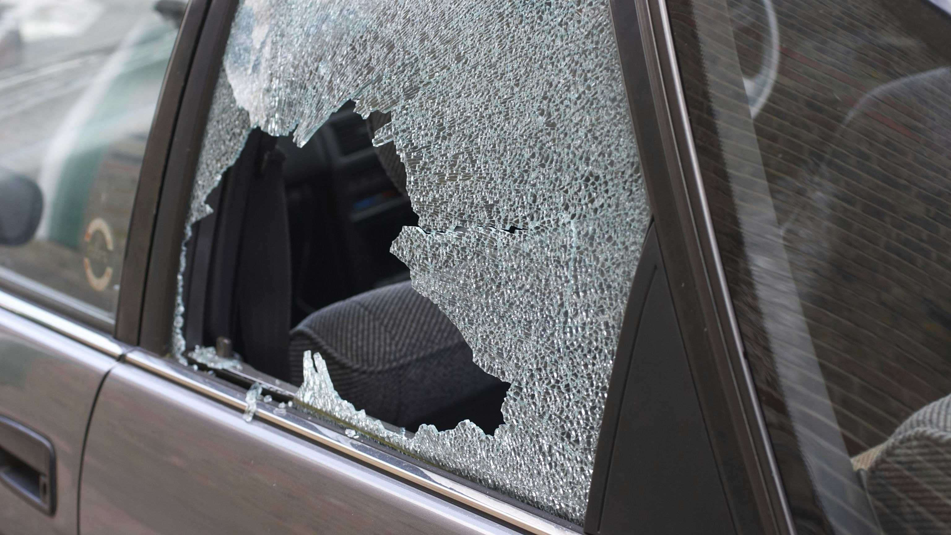Cracked and crazed glass reveals the workings of a thief in the night, during the morning after. One more car crime in London.