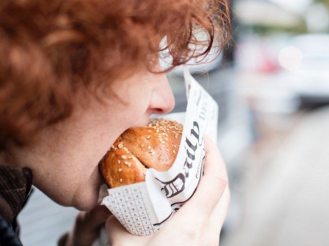 Download von www.picturedesk.com am 15.10.2021 (16:50).  A red-haired teenager biting into a hamburger - 20151102_PD15639 - Rechteinfo: Royalty Free (RF) Model Released
