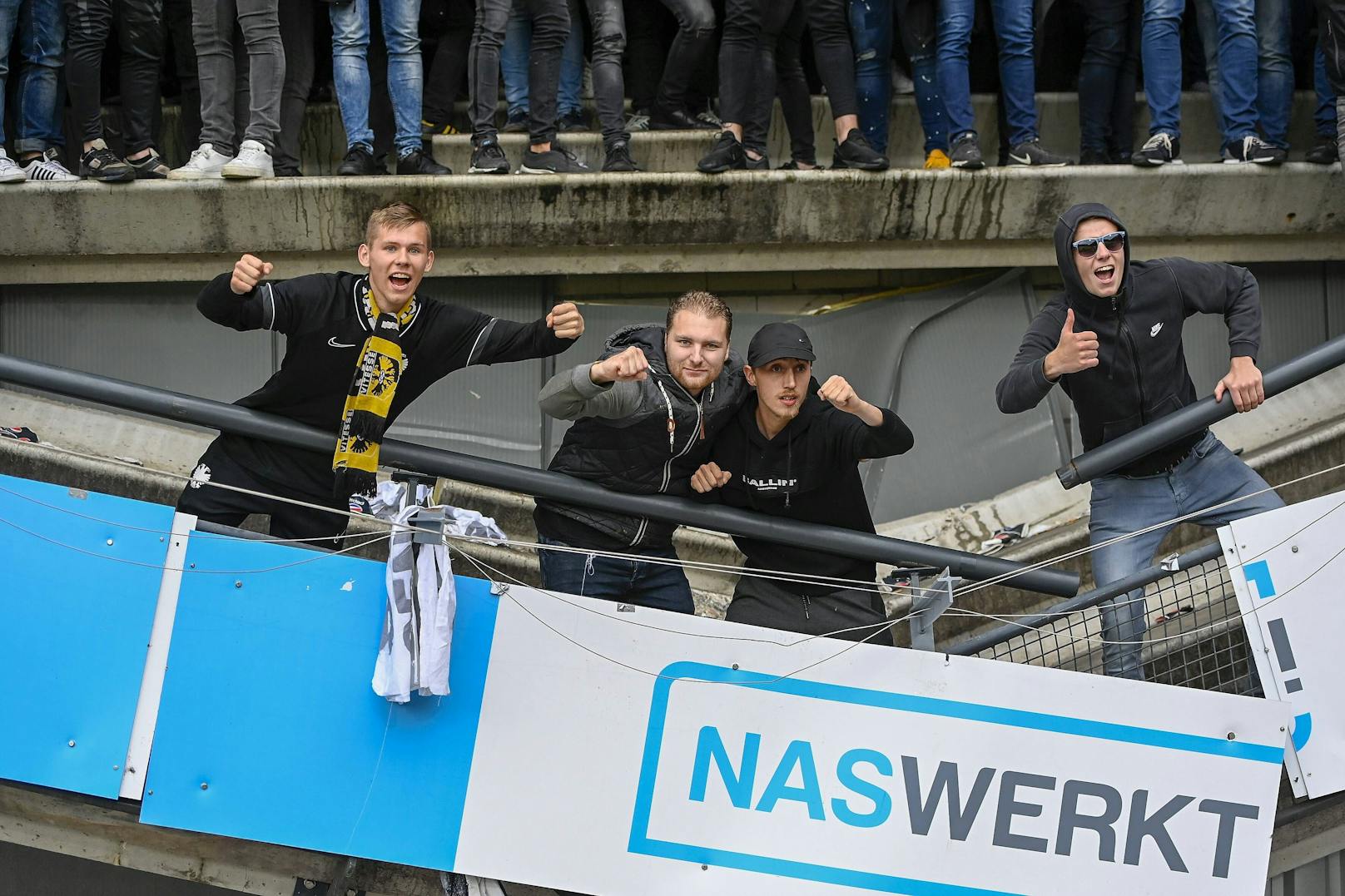 Arnheim-Fans posieren auf der eingestürzten Tribüne.