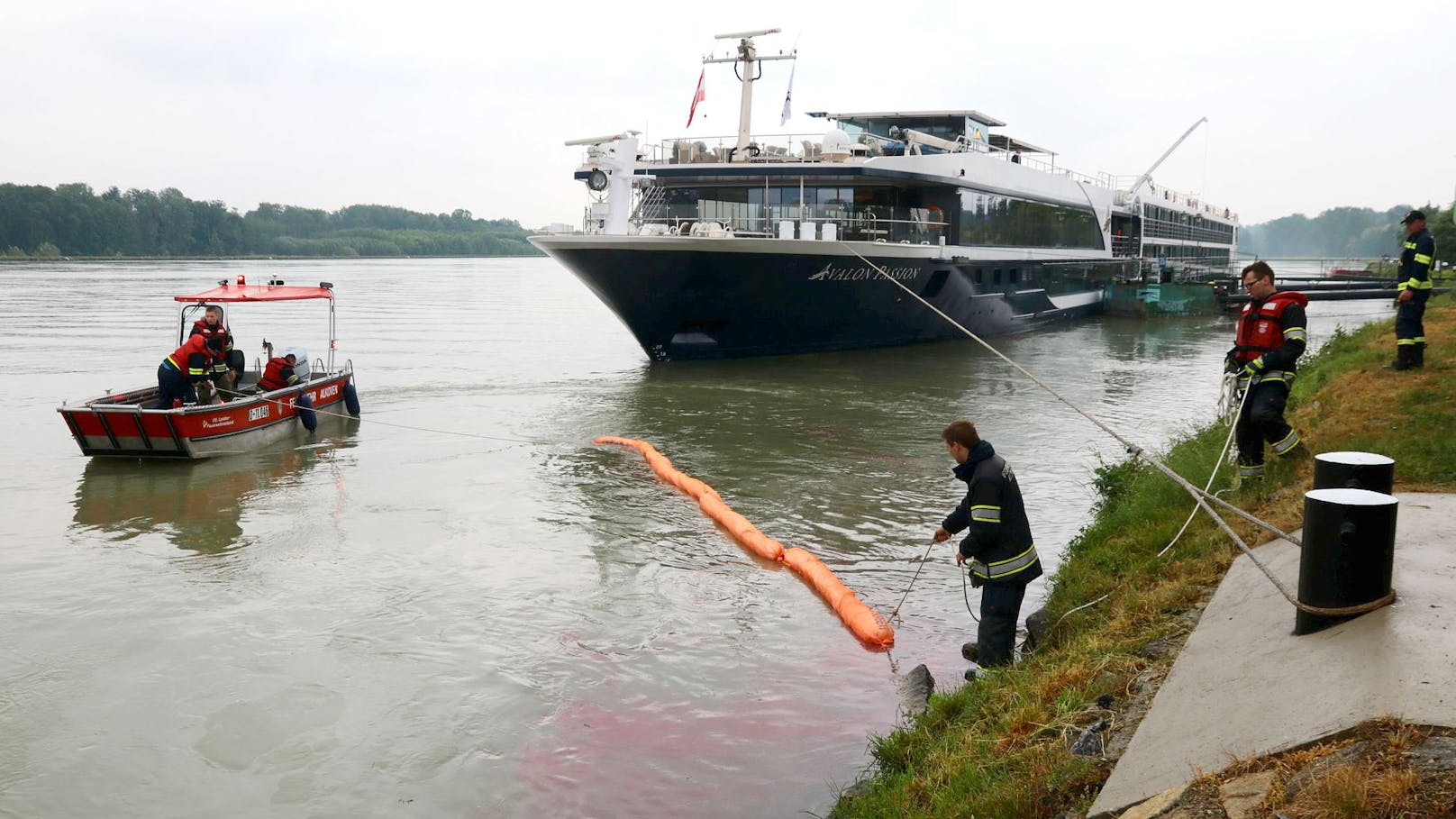 <strong>Im Bild</strong>: Kräfte der Feuerwehr beim Anbringen von Ölsperren nachdem ein leckgeschlagenes Passagierschiff<strong> Mittwoch, 16. Mai 2018</strong>, in der Anlegestelle Brandstatt einen kilometerlangen Ölfilm auf der Donau verursacht hatte.