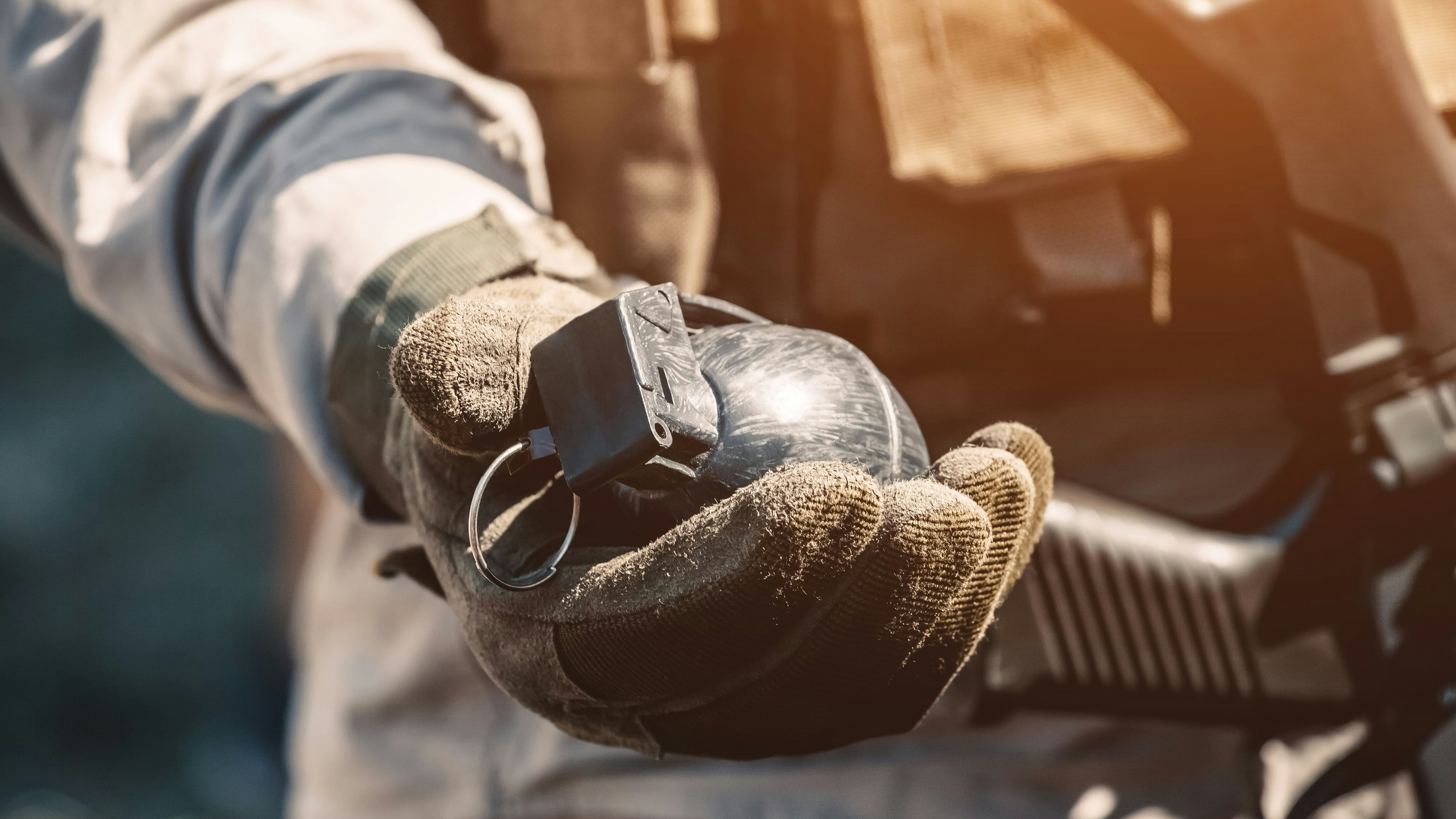 The soldier holds in his hand a training grenade while passing military exercises in the army.
