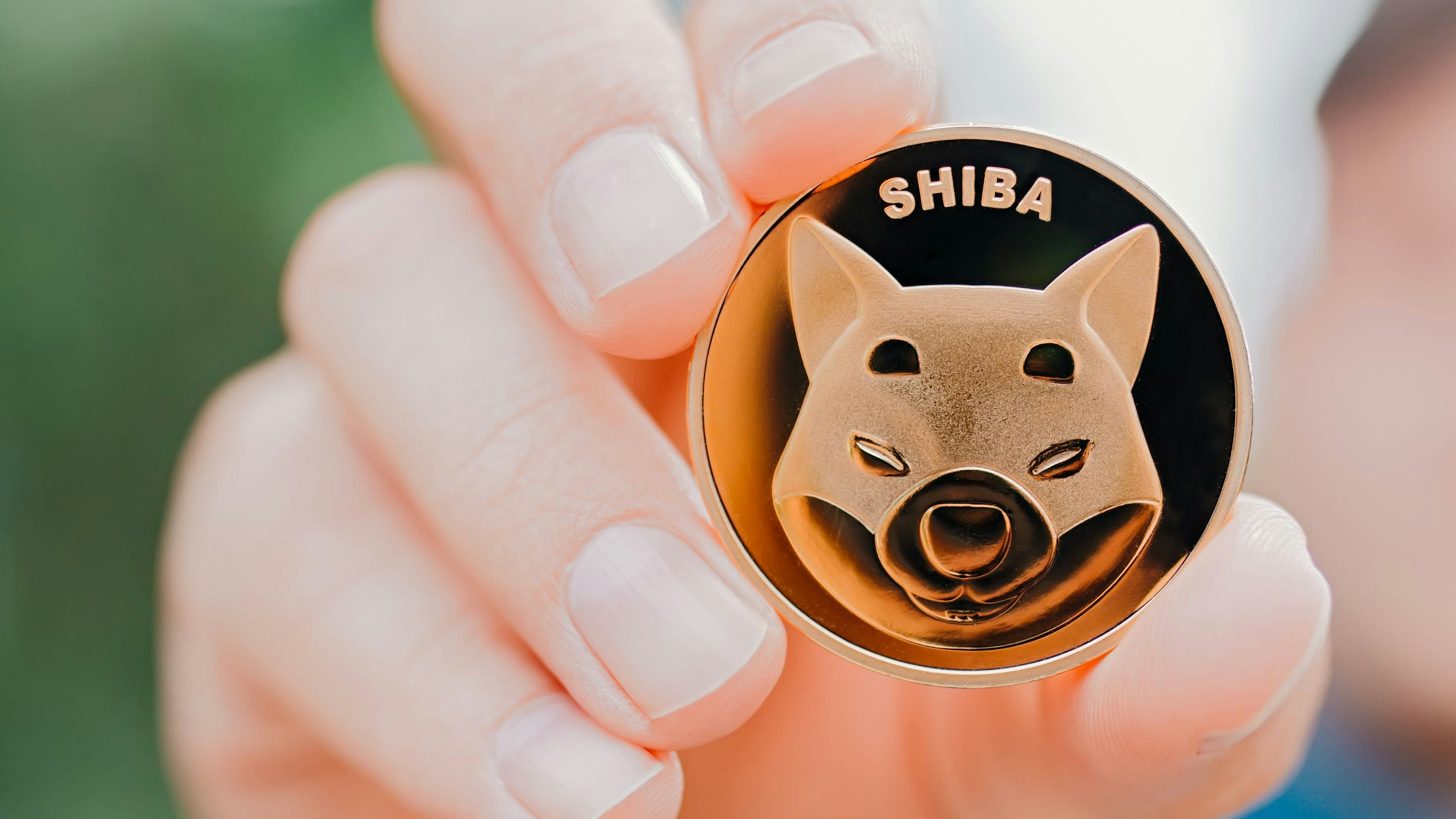 Empuriabrava, Spain, June 2021 - Man holding one Shiba token, coin with Shiba symbol, concept of investing in Shiba token