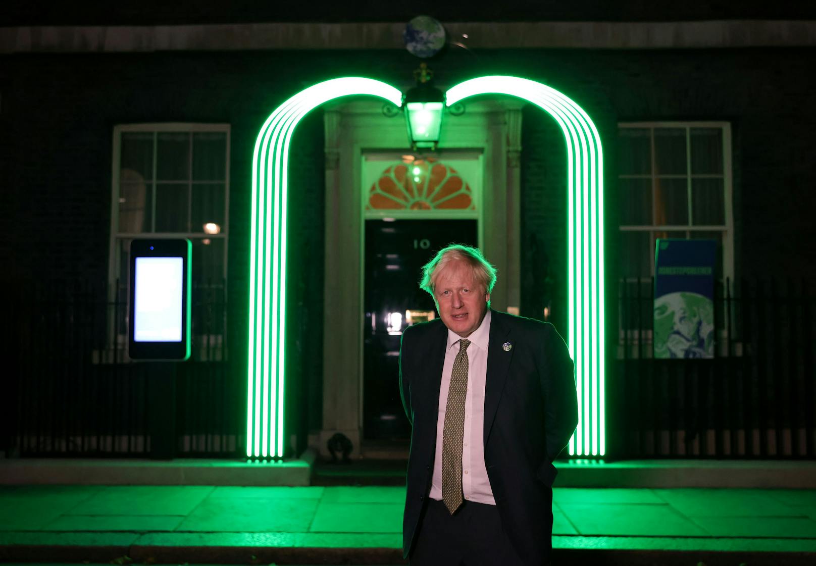 Premierminister Boris Johnson&nbsp;mit der National Grid COP26-Installation. In Vorbereitung auf den COP26-Gipfel wird ein grüner Bogen über der Tür der Downing Street Nummer 10 in London beleuchtet.