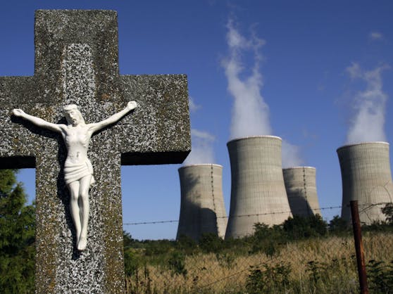 Ein steinernes Kruzifix vor den Türmen des Atomkraftwerks Mochovce in der Slowakei. Der Ausbau der Atomenergie wird rund um die Weltklimakonferenz heftig debattiert.