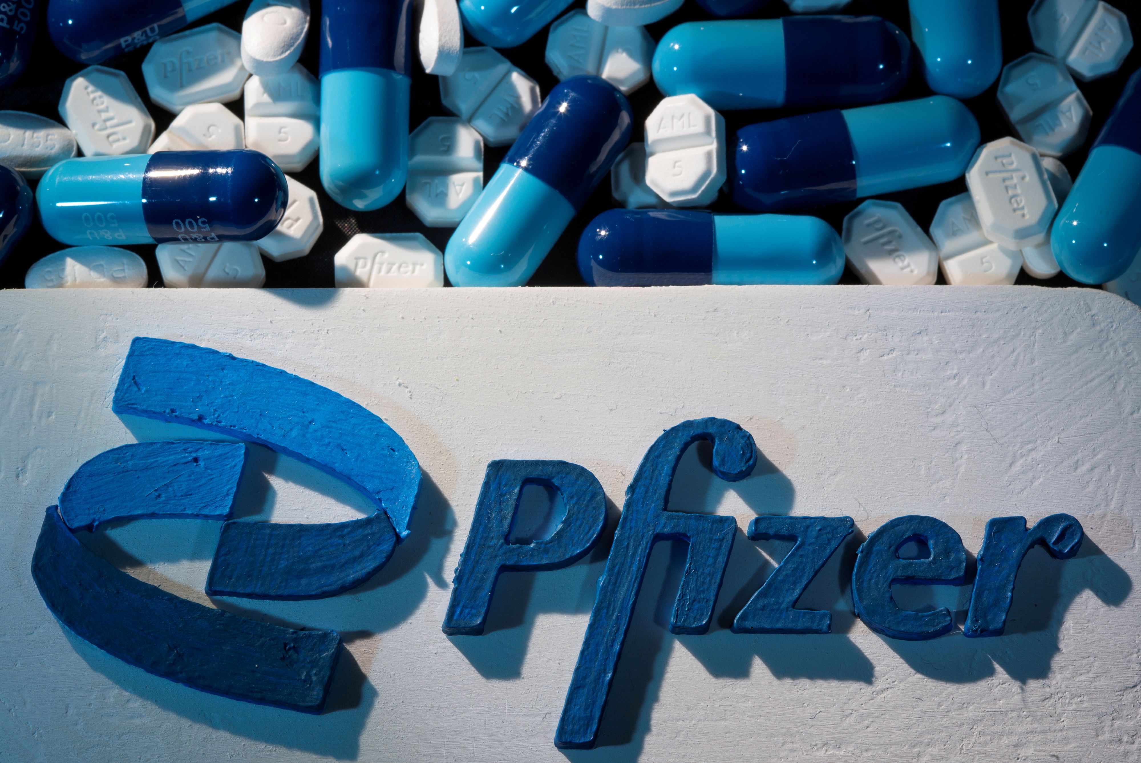 FILE PHOTO: A 3D printed Pfizer logo is placed near medicines from the same manufacturer in this illustration taken September 29, 2021. REUTERS/Dado Ruvic/Illustration/File Photo
