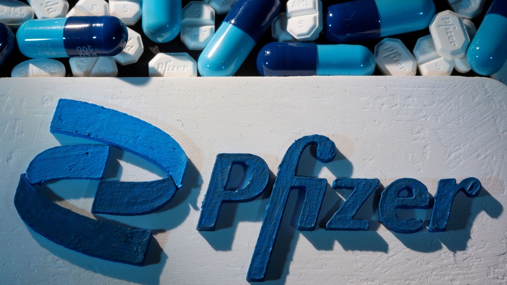 FILE PHOTO: A 3D printed Pfizer logo is placed near medicines from the same manufacturer in this illustration taken September 29, 2021. REUTERS/Dado Ruvic/Illustration/File Photo