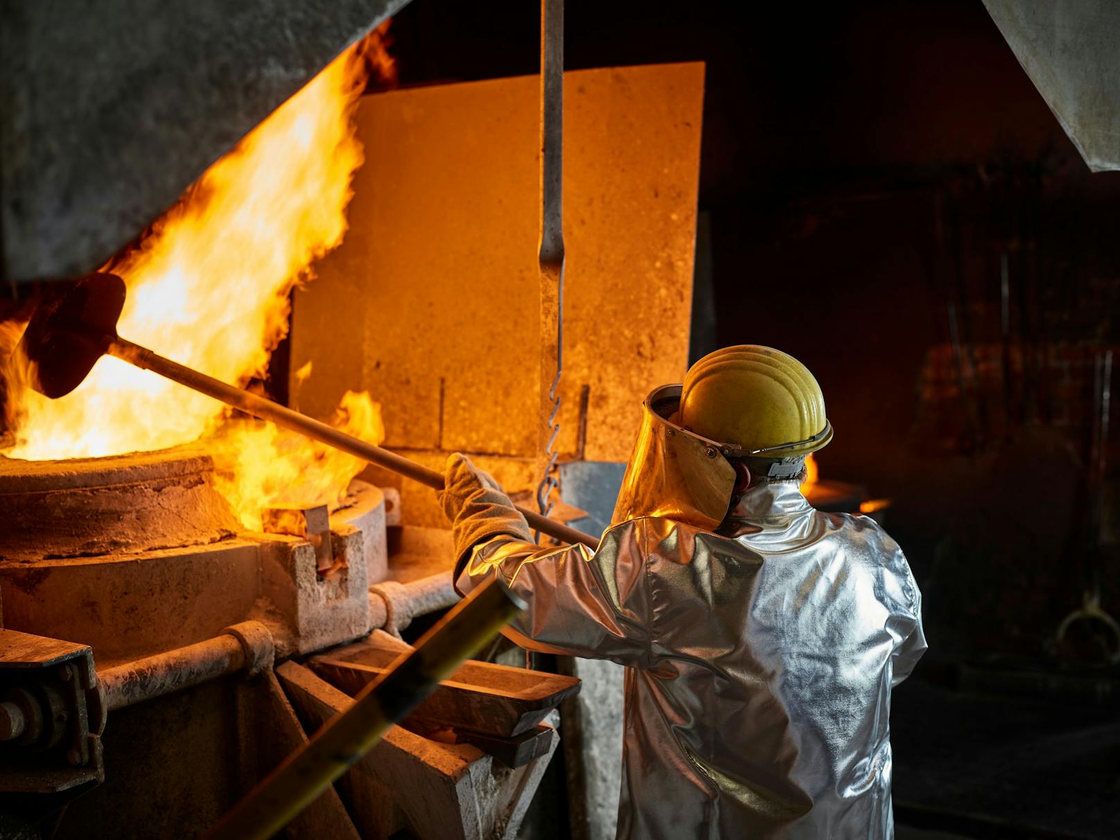 Metallarbeiter an einem Schmelzofen. Symbolbild