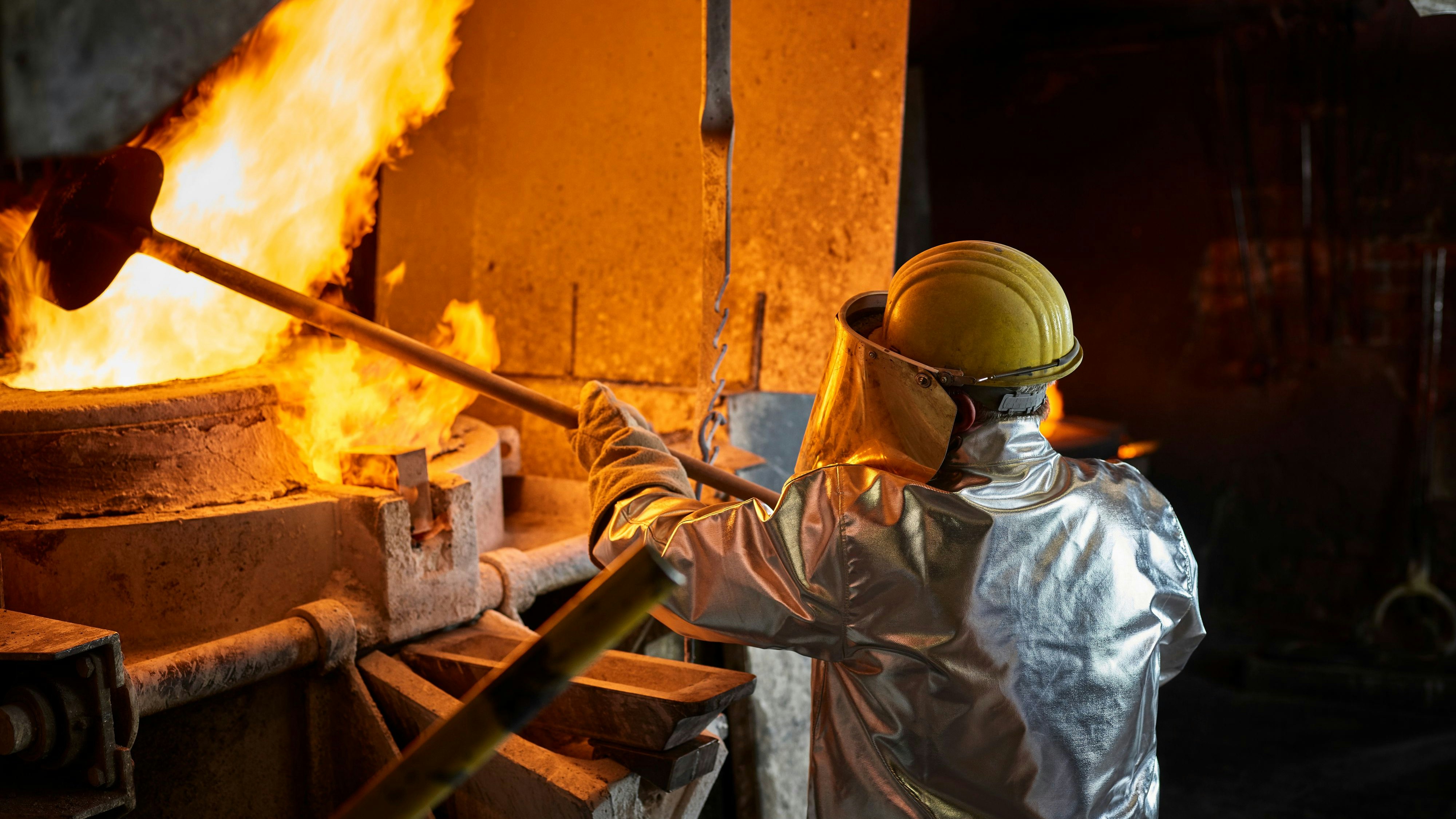 Metallarbeiter an einem Schmelzofen. Symbolbild