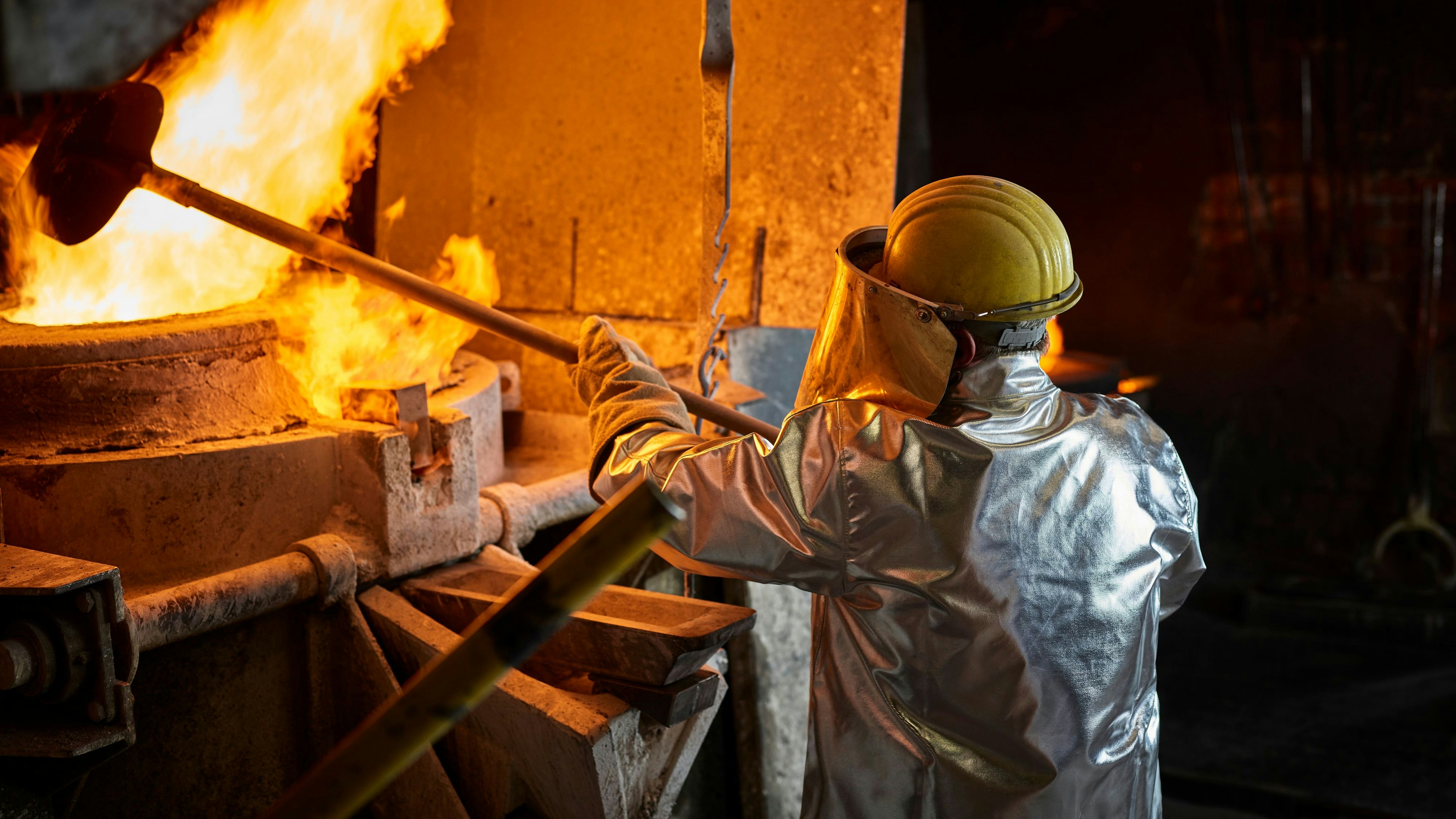 Metallarbeiter an einem Schmelzofen. Symbolbild
