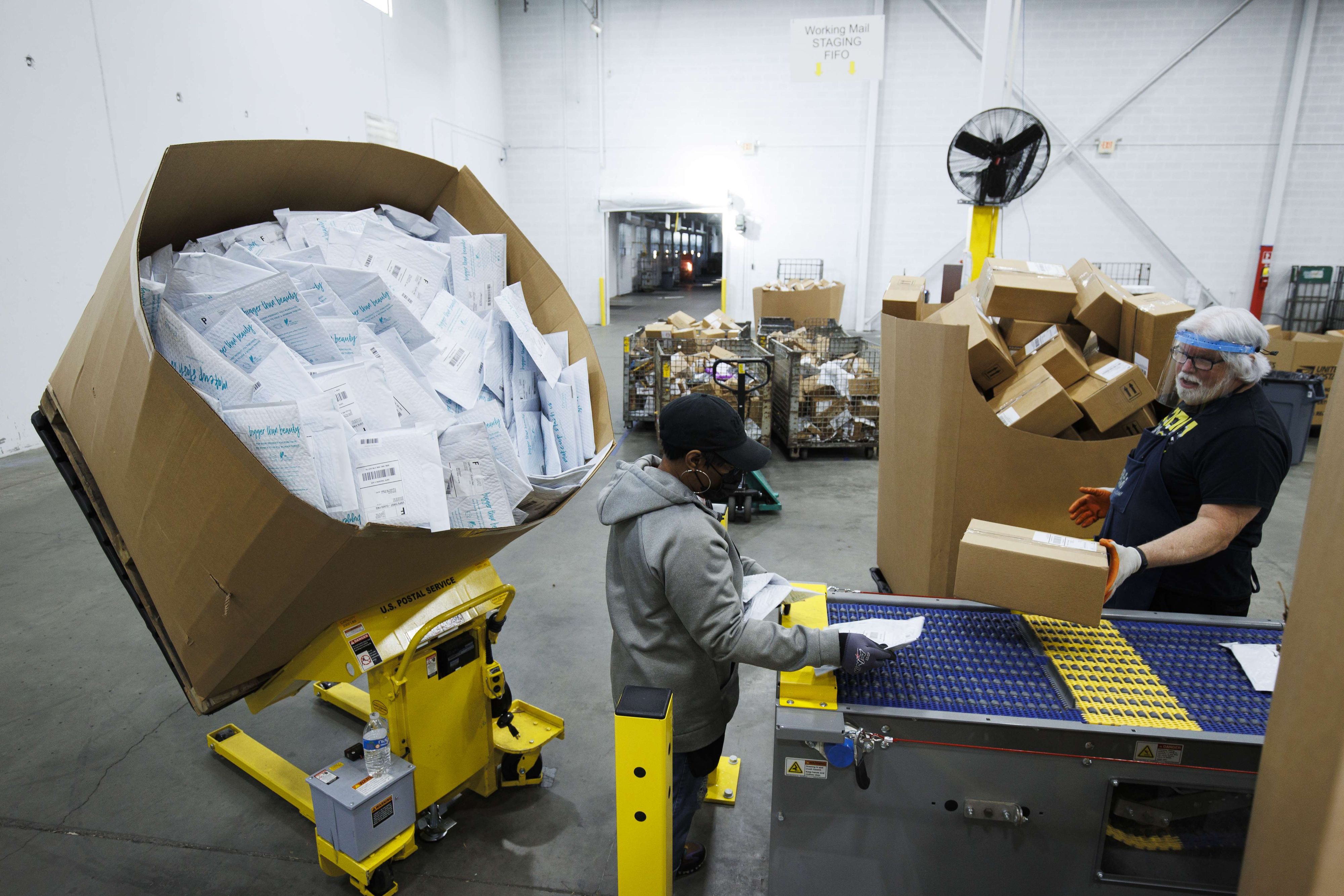 Download von www.picturedesk.com am 08.11.2021 (13:08).  LA VERGNE, TN - NOVEMBER 04: Workers load mail onto a Single Induction Parcel Sorter which sorts up to 3,000 machinable parcels per hour during a media tour of a United States Postal Service package support annex on November 4, 2021 in La Vergne, Tennessee. USPS saw a 48 percent demand increase for package delivery last holiday season. Brett Carlsen/Getty Images/AFP.== FOR NEWSPAPERS, INTERNET, TELCOS & TELEVISION USE ONLY == - 20211104_PD13886 - Rechteinfo: Rights Managed (RM) Fotografische Urheberrechte sind garantiert. Der Kunde selbst hat insbesondere die Persönlichkeitsrechte der abgebildeten Personen in eigener Verantwortung zu beachten (AGBs Punkt 5). Nur für redaktionelle Nutzung durch Tageszeitungen und Onlinemedien!