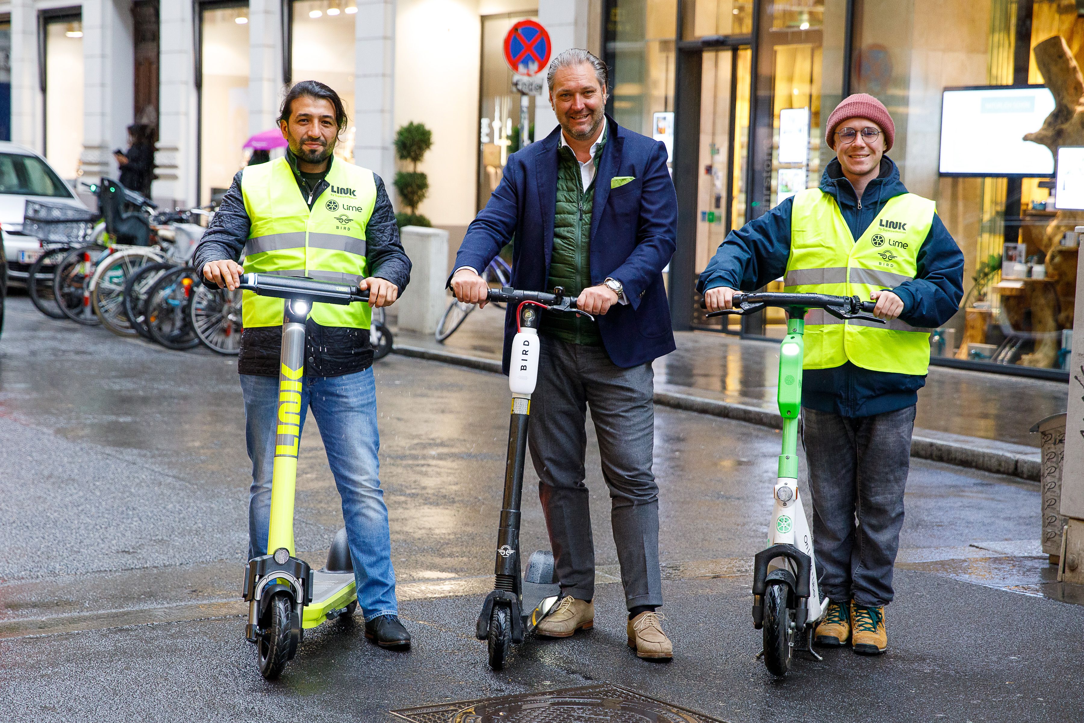 Dieter Steup, WK Wien Bezirksobmann der Inneren Stadt, mit Scooter-Ordnern der Unternehmen Lime, Link und Bird. Die Ordner sind gut sichtbar mit Westen samt Logos der drei Anbieter unterwegs. 