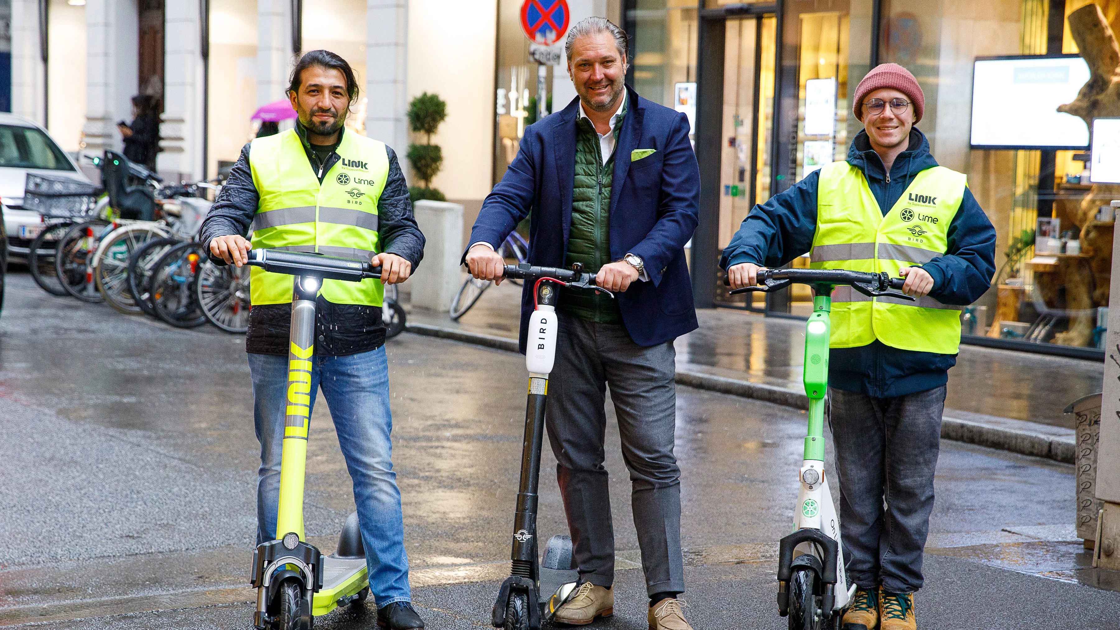 Dieter Steup, WK Wien Bezirksobmann der Inneren Stadt, mit Scooter-Ordnern der Unternehmen Lime, Link und Bird. Die Ordner sind gut sichtbar mit Westen samt Logos der drei Anbieter unterwegs. 