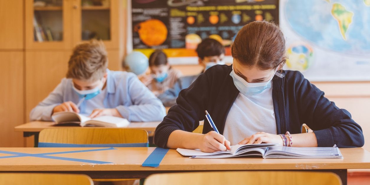High school students at school, wearing N95 Face masks. Sitting in a classroom.