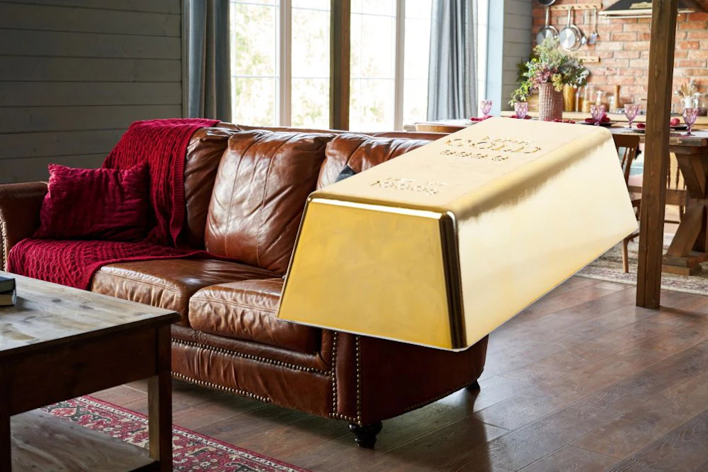 Symbolfotos eines Goldbarren und einer Couch.