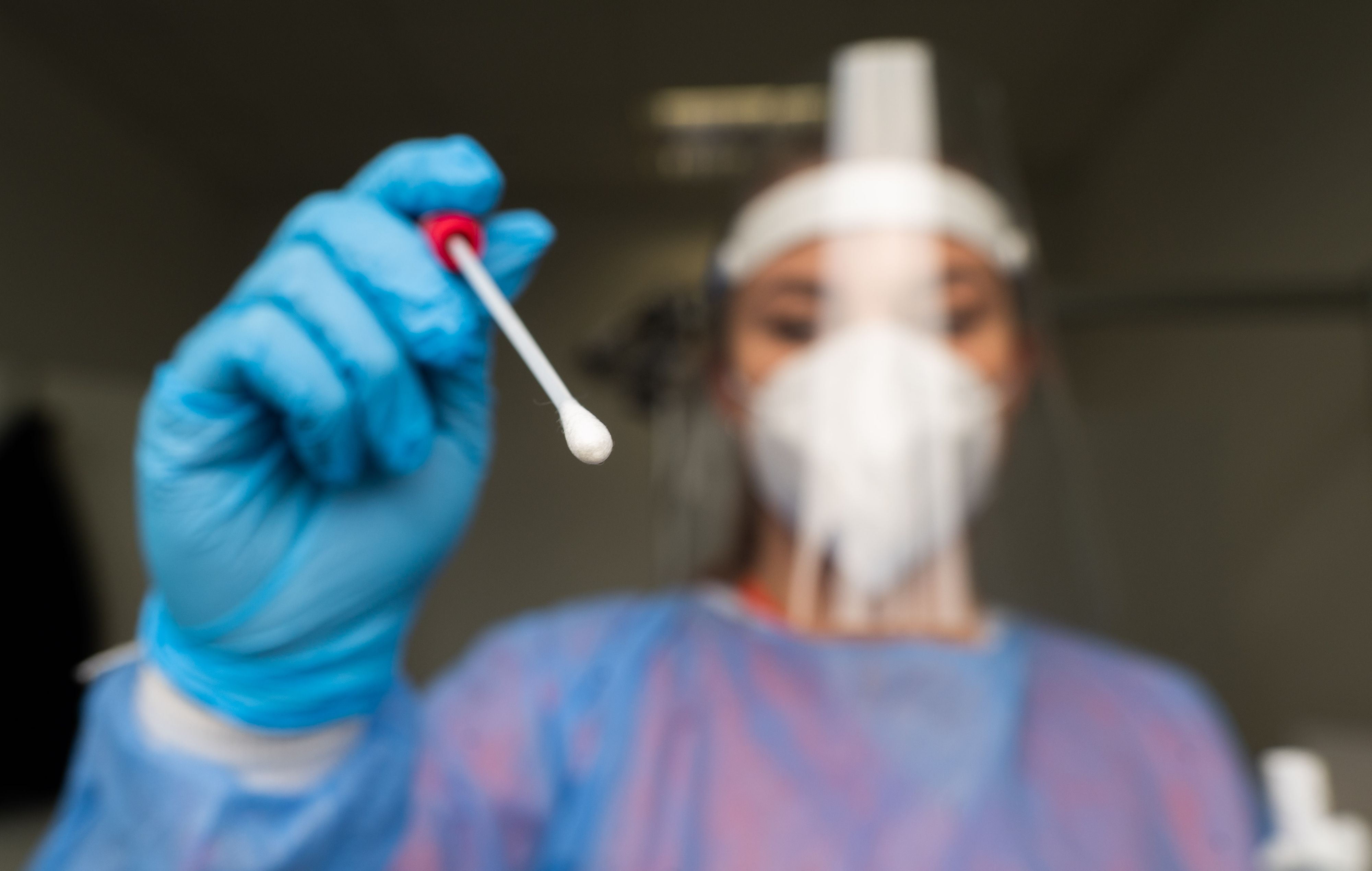 Download von www.picturedesk.com am 13.11.2021 (10:58).  12 November 2021, Lower Saxony, Laatzen: A staff member stands with a test stick for a smear test in the Corona test centre Hanover-Laatzen in the Hanover region, which is operated by a doctor's practice. The nationwide seven-day incidence has risen again. Photo: Julian Stratenschulte/dpa - 20211112_PD1364 - Rechteinfo: Rights Managed (RM)