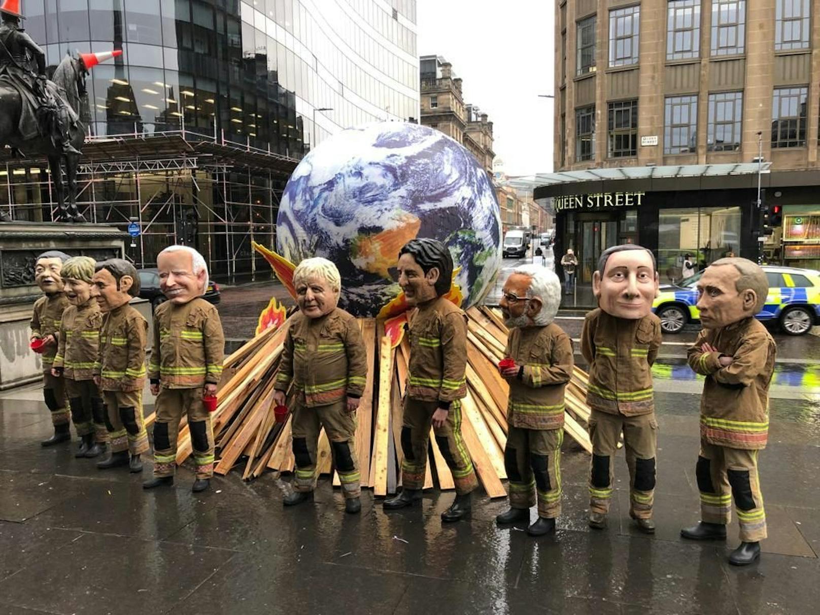 Im Zentrum von Glasgow demonstrierten am Freitag Umweltschützer gegen ambitionslose Klimapolitik. Sie zeigten Politiker, die versuchen, die brennende Welt mit viel zu kleinen Wasserbehältern zu löschen.