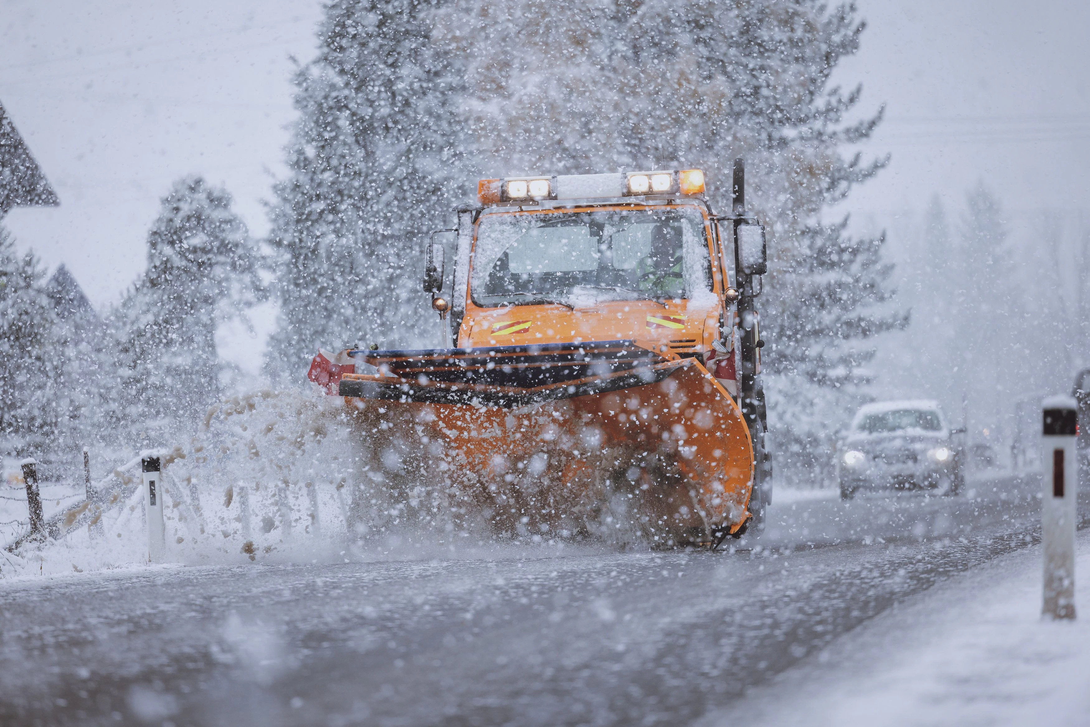 Ein Räumfahrzeug des Winterdienstes räumt bei starkem Schneefall die Strasse in Kaprun