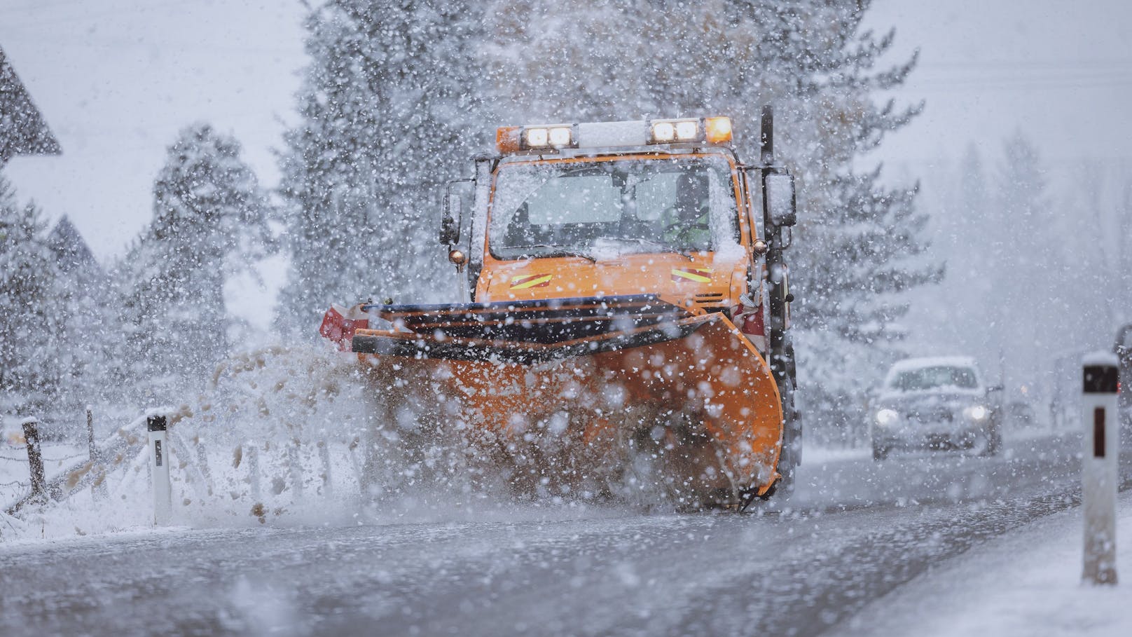 Ein Räumfahrzeug des Winterdienstes räumt bei starkem Schneefall eine Straße. In OÖ kam es zu einem kuriosen Zwischenfall.