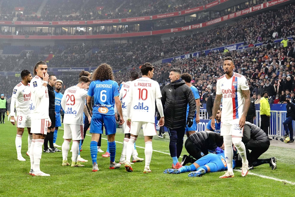 Dimitri Payet liegt am Boden, nachdem ihn eine Wasserflasche am Kopf getroffen hatte.