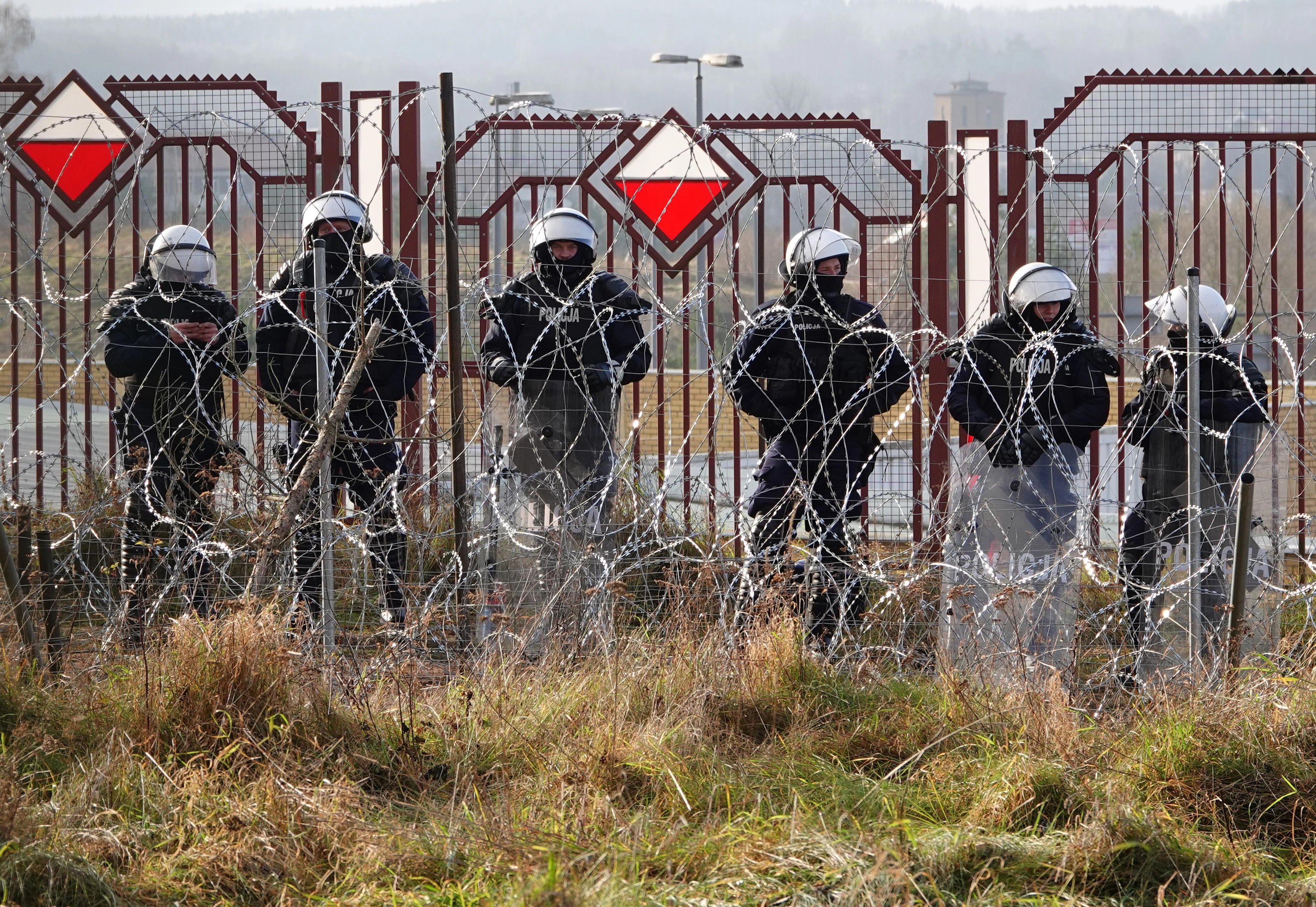 Download von www.picturedesk.com am 22.11.2021 (21:39).  18 November 2021, Belarus, Brusgi: Polish security forces stand behind barbed wire at the border. Photo: Ulf Mauder/dpa - 20211118_PD6039 - Rechteinfo: Rights Managed (RM)