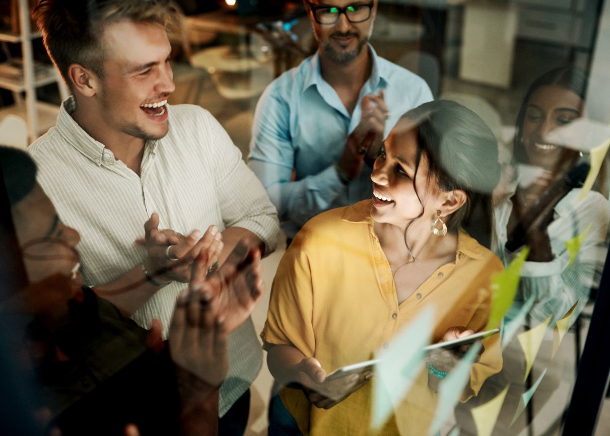 Shot of a group of businesspeople using a digital tablet during a late night brainstorming session in a modern office
