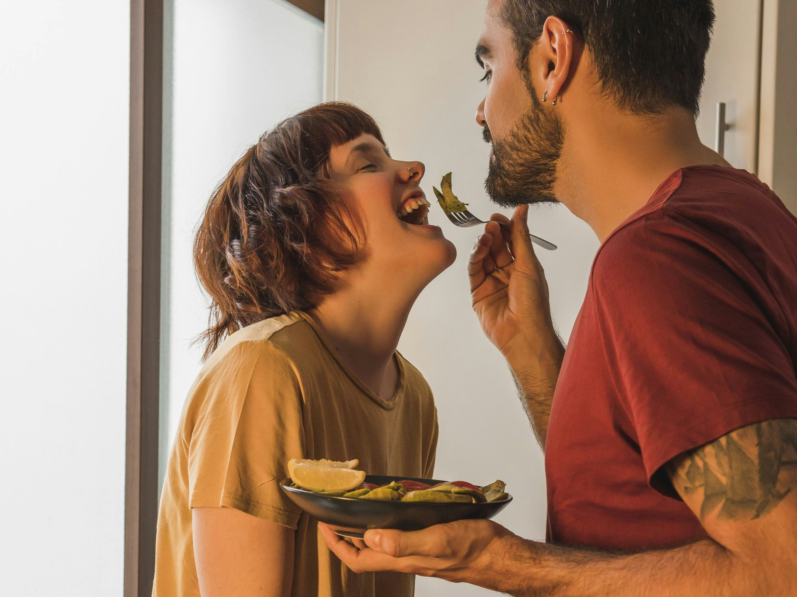 Download von www.picturedesk.com am 26.11.2021 (14:50).  Man feeding girlfriend with salad in kitchen at home - 20210824_PD12786 - Rechteinfo: Royalty Free (RF) Model Released