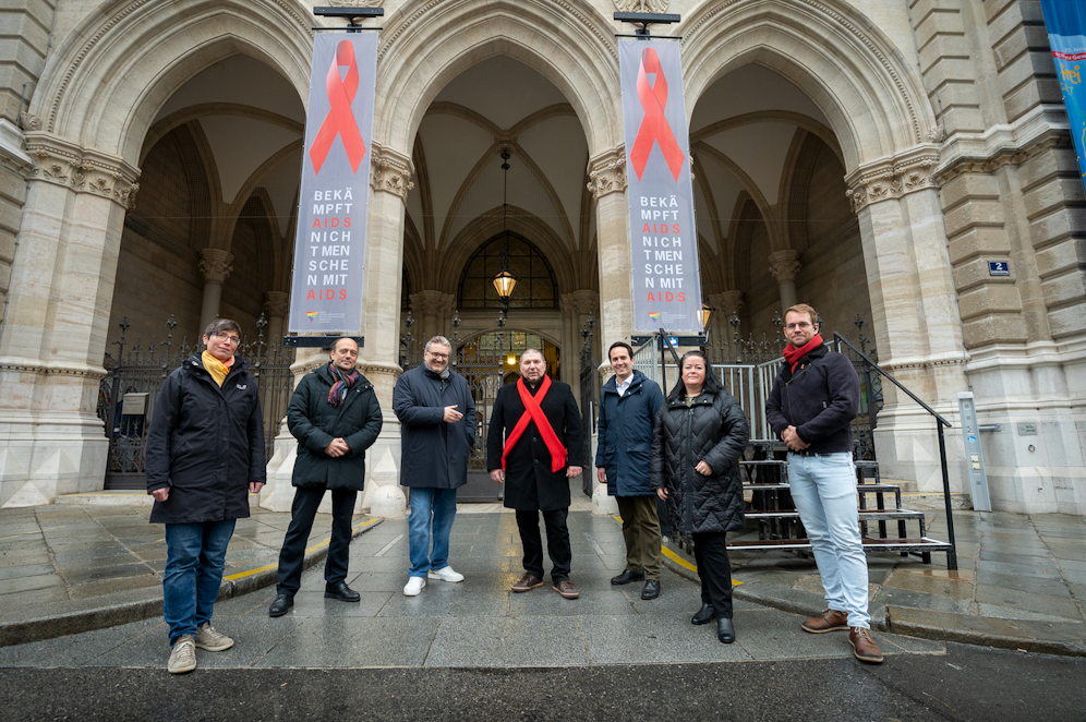 Vizebürgermeister Christoph Wiederkehr (3.v.re.), Gesundheitsstadtrat Peter Hacker (3.v.li.) und das Team der WASt-Wiener Antidiskriminierungsstelle für LGBTIQ-Angelegenheiten hissen gemeinsam anlässlich des Welt-AIDS-Tages den Red Ribbon am Wiener Rathaus. 