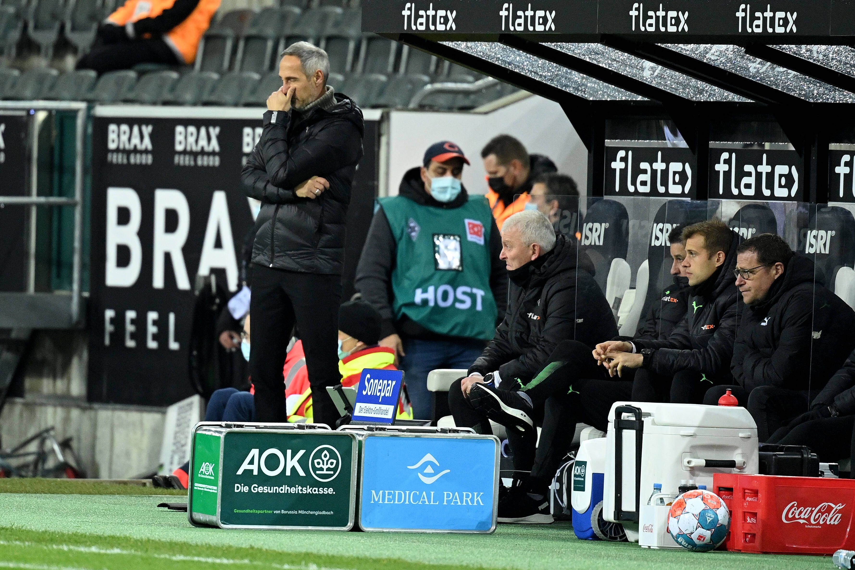 Adi Hütter (l.) blickt beschämt in Richtung Spielfeld, Sportdirektor Max Eberl (r.) stärkt ihm den Rücken. 