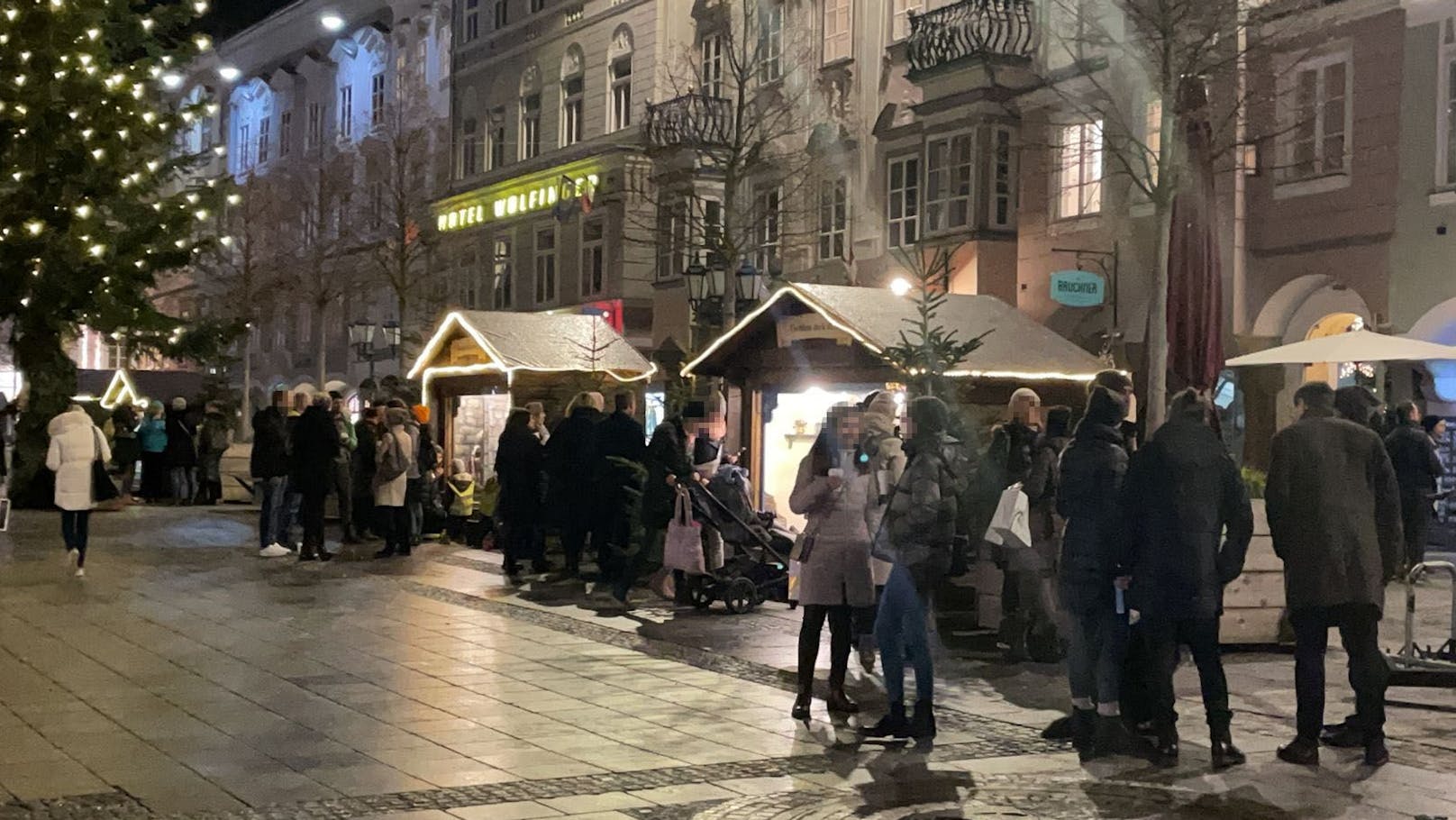 Mit Punsch und Glühwein stehen die Leute neben den Märchen-Hütten am Linzer Hauptplatz. Der heimliche Christkindlmarkt sorgt jetzt für Ärger.