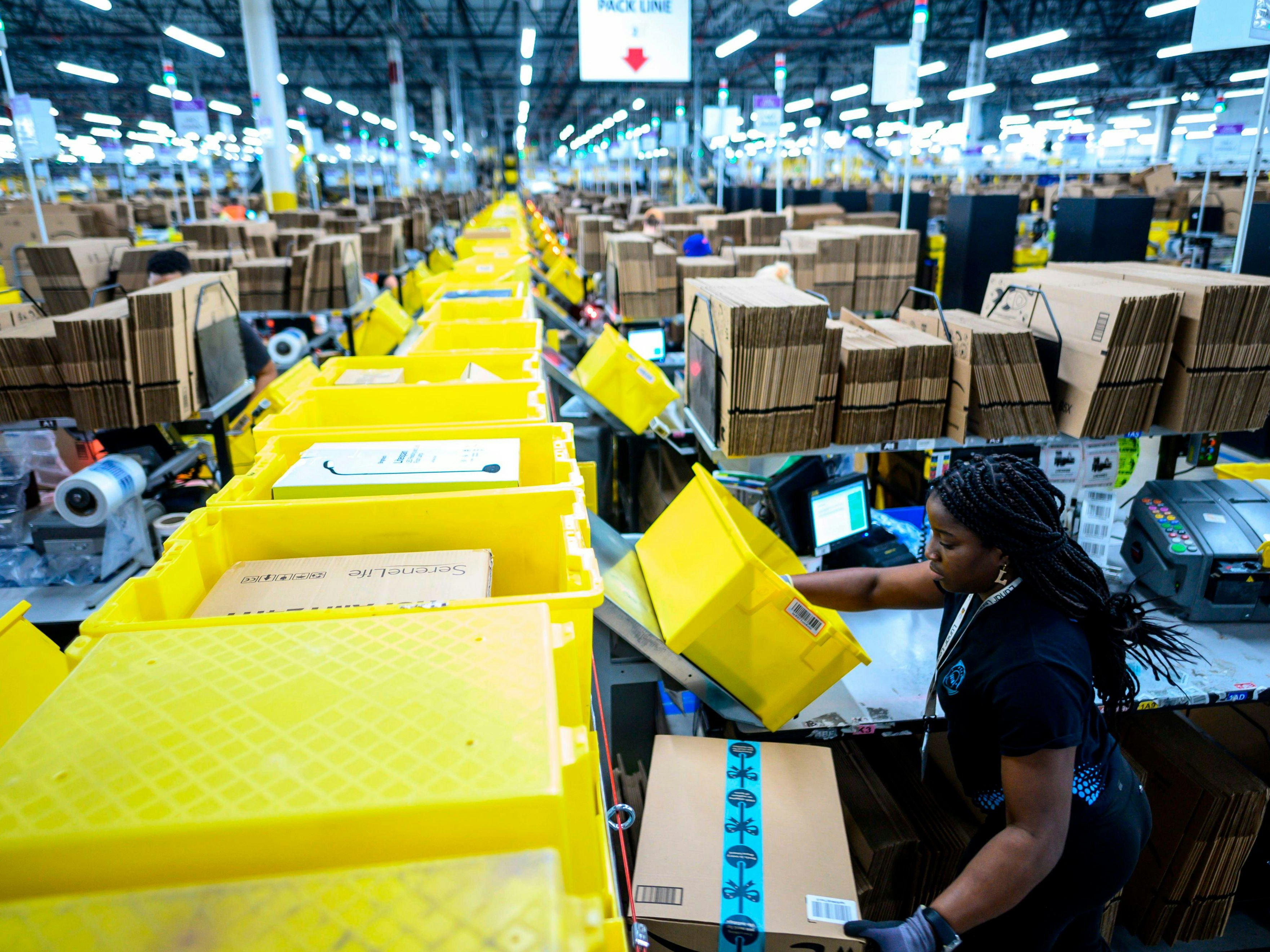 Download von www.picturedesk.com am 09.12.2021 (10:52).  (FILES) In this file photo taken on February 5, 2019 a woman works at a packing station at the 855,000-square-foot Amazon fulfillment center in Staten Island, one of the five boroughs of New York City. - Hundreds of Amazon employees on January 26, 2020 openly criticized the online retail giant's environmental record, in violation of the company's communications policy. More than 300 signed a Medium blog post by Amazon Employees for Climate Justice (AECJ), which is pushing the company to go further in its climate change mitigation plan which was announced with great publicity in September. (Photo by Johannes EISELE / AFP) - 20190205_PD19005 - Rechteinfo: Rights Managed (RM) Nur für redaktionelle Nutzung! Werbliche Nutzung erfordert Freigabe: bitte schicken Sie uns eine Anfrage.