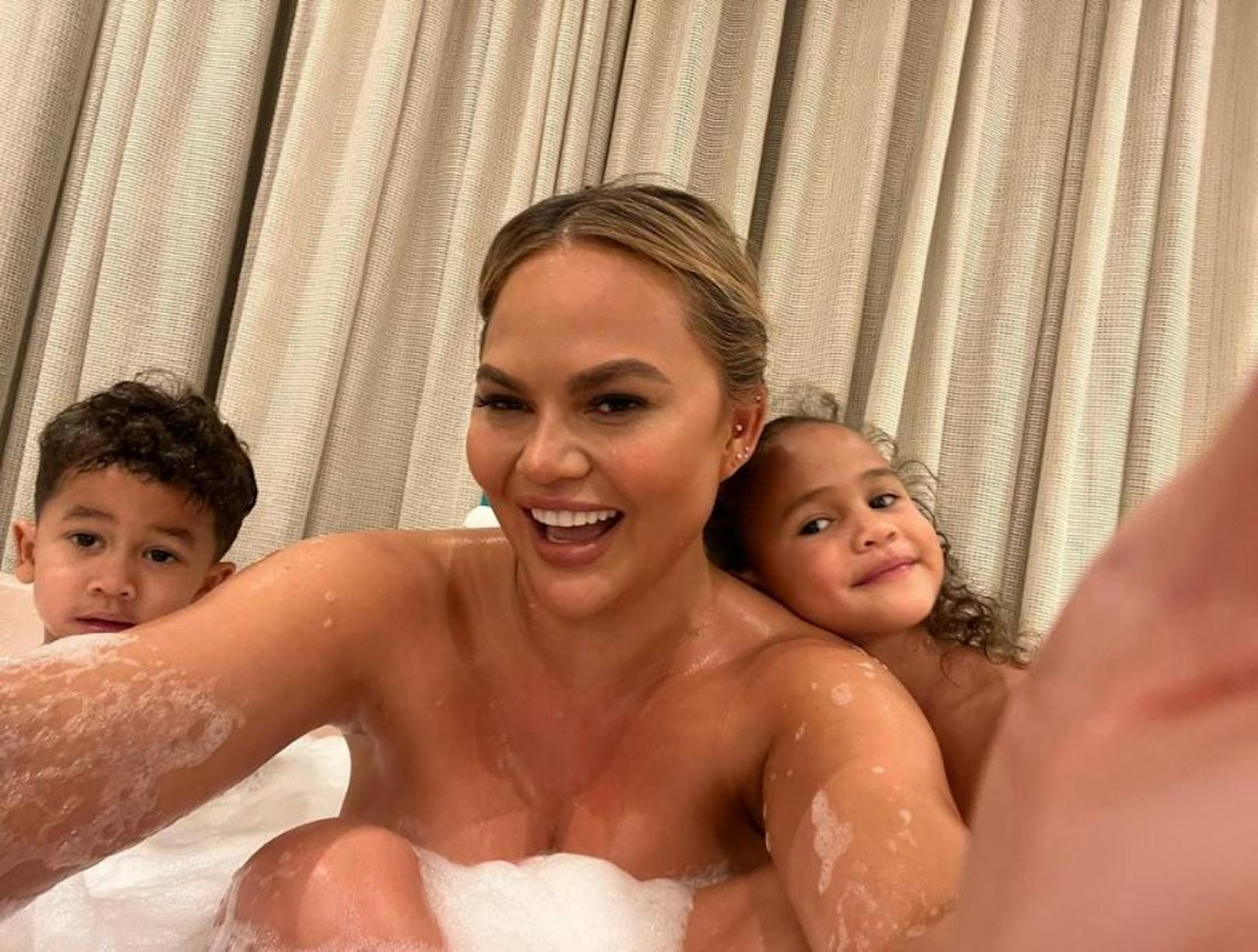 Chrissy Teigen badet mit ihren Kids. Von einigen Fans hagelte es Kritik. "So nackt darfst du dich nicht vor deinem Sohn zeigen", meint ein User.