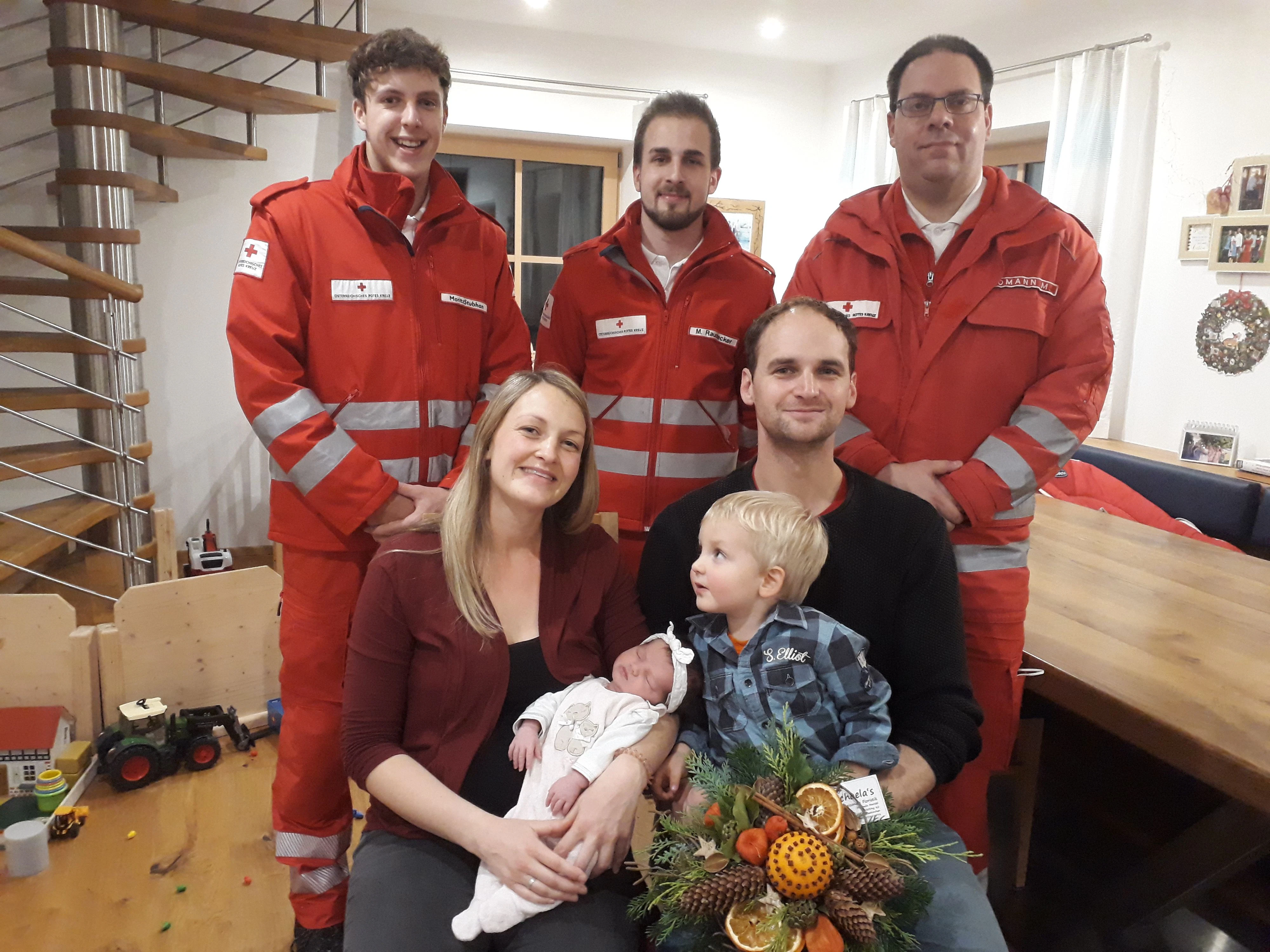 Die glückliche Familie mit den Geburtshelfern vom Roten Kreuz.