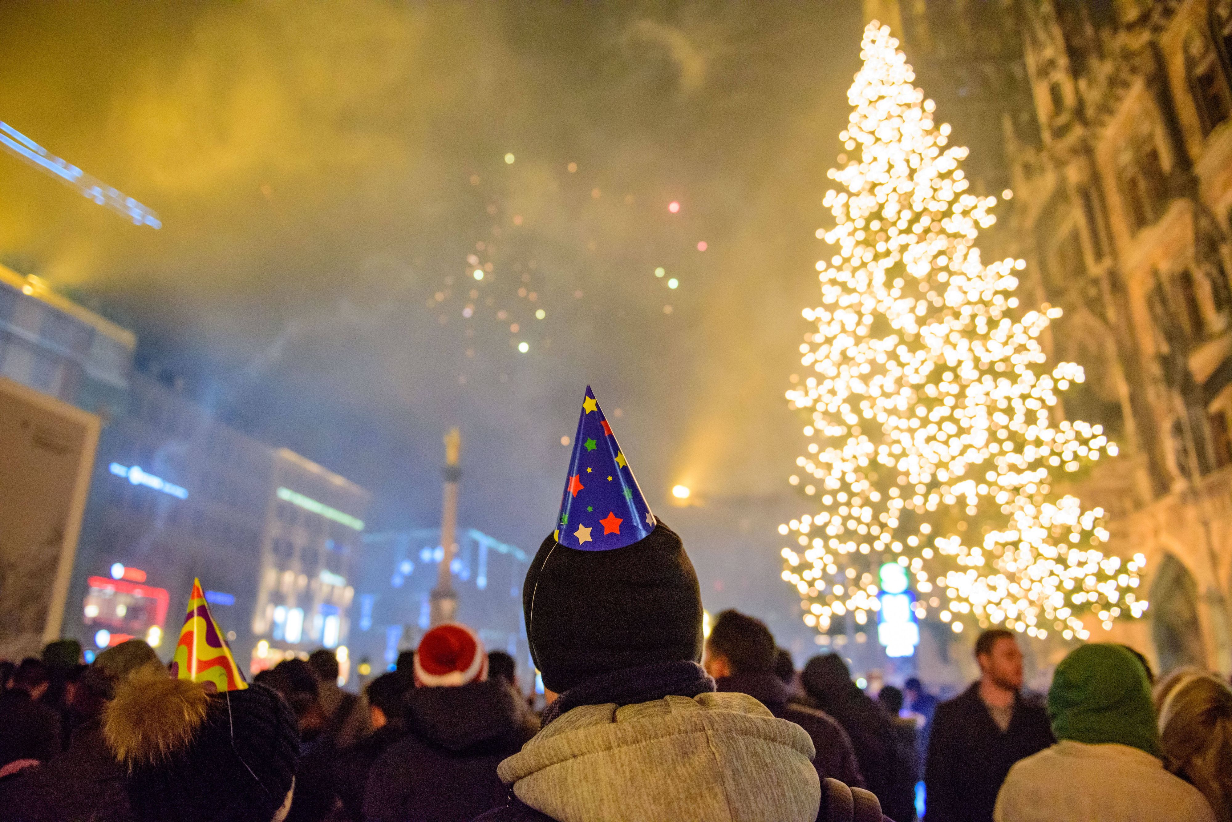 Download von www.picturedesk.com am 17.12.2021 (10:44).  Menschen bestaunen das Feuerwerk zum Jahreswechsel 2016/17 über dem Marienplatz in München. - 20170101_PD9704 - Rechteinfo: Rights Managed (RM)