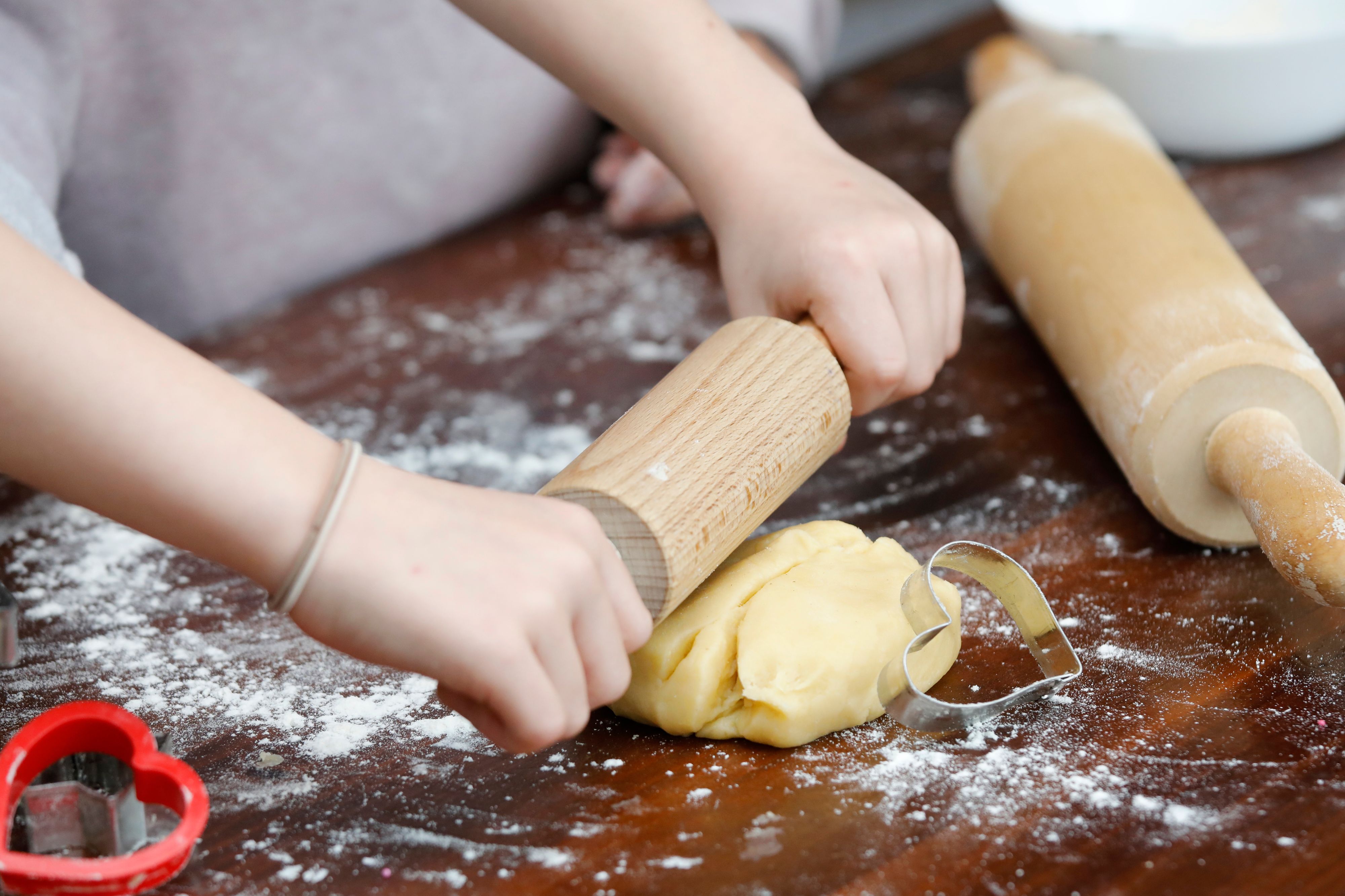 Child's hand with ingredients for Christmas cookies.
