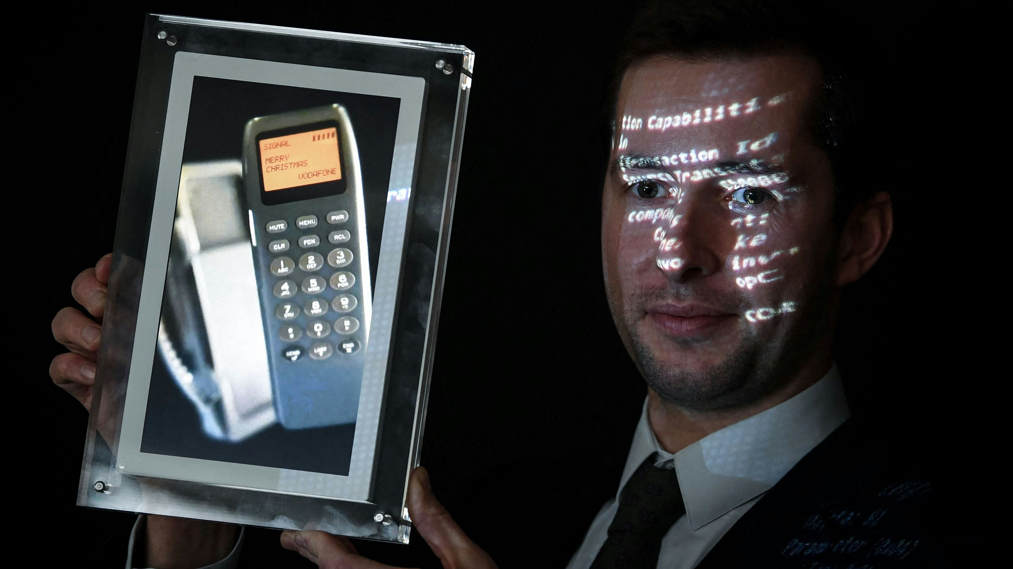 Download von www.picturedesk.com am 21.12.2021 (15:46).  Maximillien Aguttes, Aguttes auction house's development manager, presents a screen showing a phone with the first ever SMS in the world, a day before it is auctionned as an ntf on December 20, 2021 at the Aguttes auction house in Neuilly-sur-Seine west of Paris. - The worlds first SMS, whose message was "Merry Christmas", was received via the Vodafone network by the director of the telecommunications operator Vodafone, on December 3, 1992. (Photo by ALAIN JOCARD / AFP) - 20211220_PD3679 - Rechteinfo: Rights Managed (RM) Nur fÃ¼r redaktionelle Nutzung! Werbliche Nutzung erfordert Freigabe: bitte schicken Sie uns eine Anfrage.