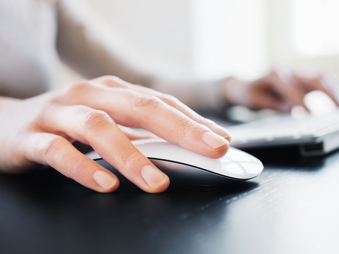 Close-up of female hand with computer mouse. Shallow DOF.